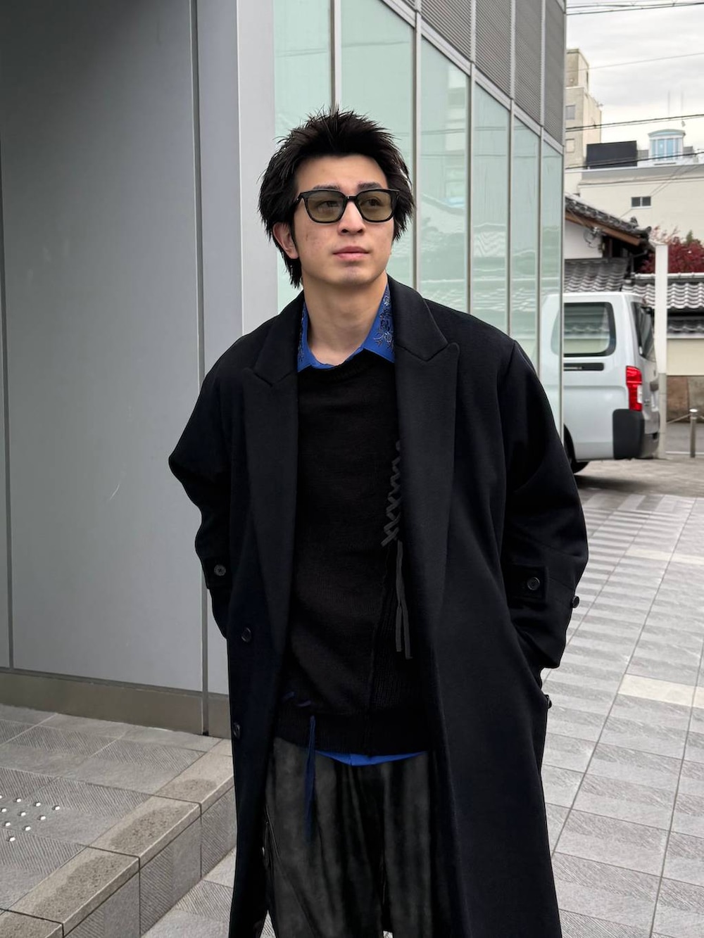 ブラック系のチェスターコート、グレー系のカーゴパンツ、ブラック系のスニーカーを着用したメンズの冬コーディネートの2枚目の写真