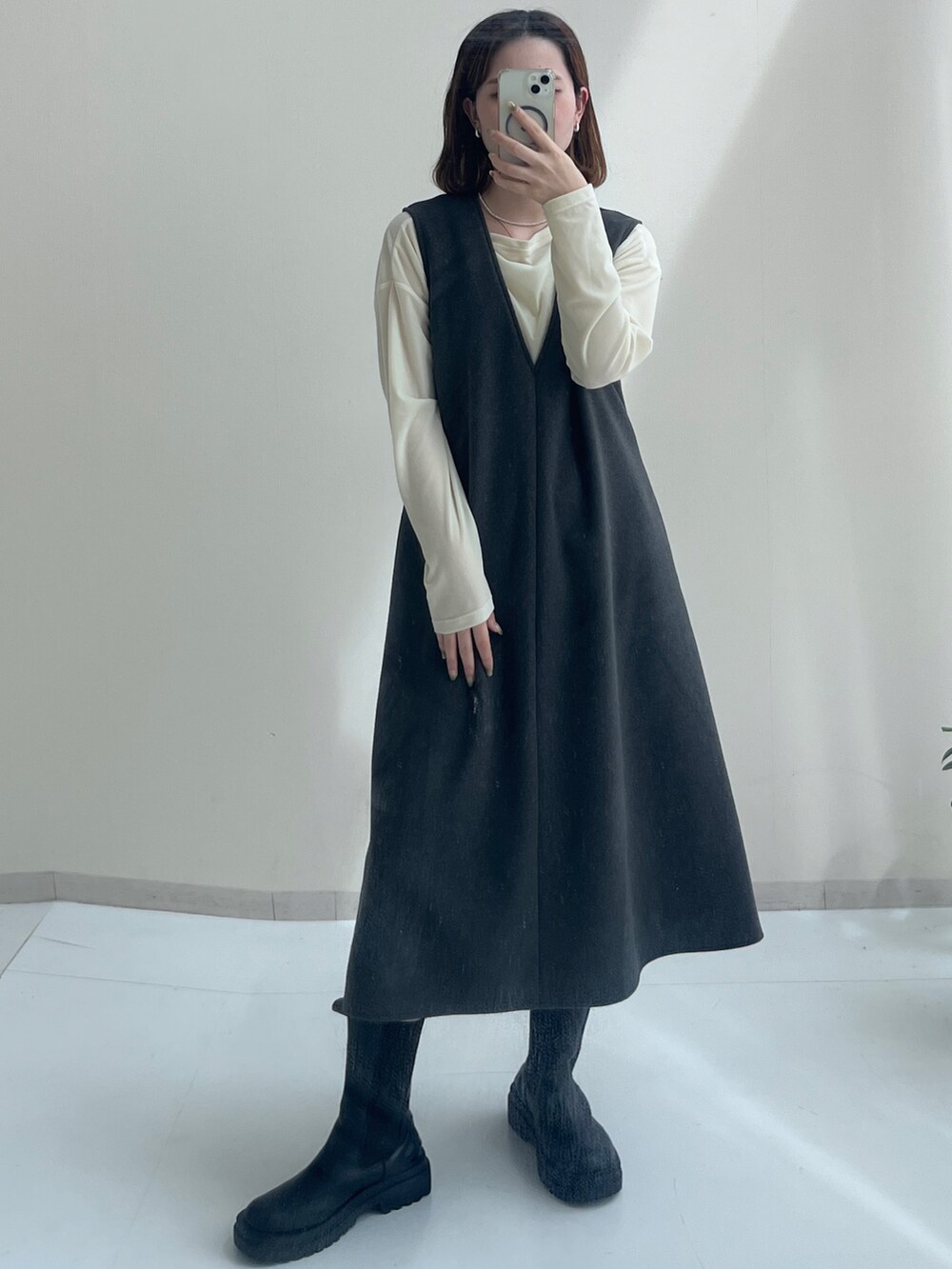 ベージュ系のTシャツ/カットソー、ホワイト系のTシャツ/カットソー、グレー系のジャンパースカートを着用したレディースの秋コーディネートの3枚目の写真