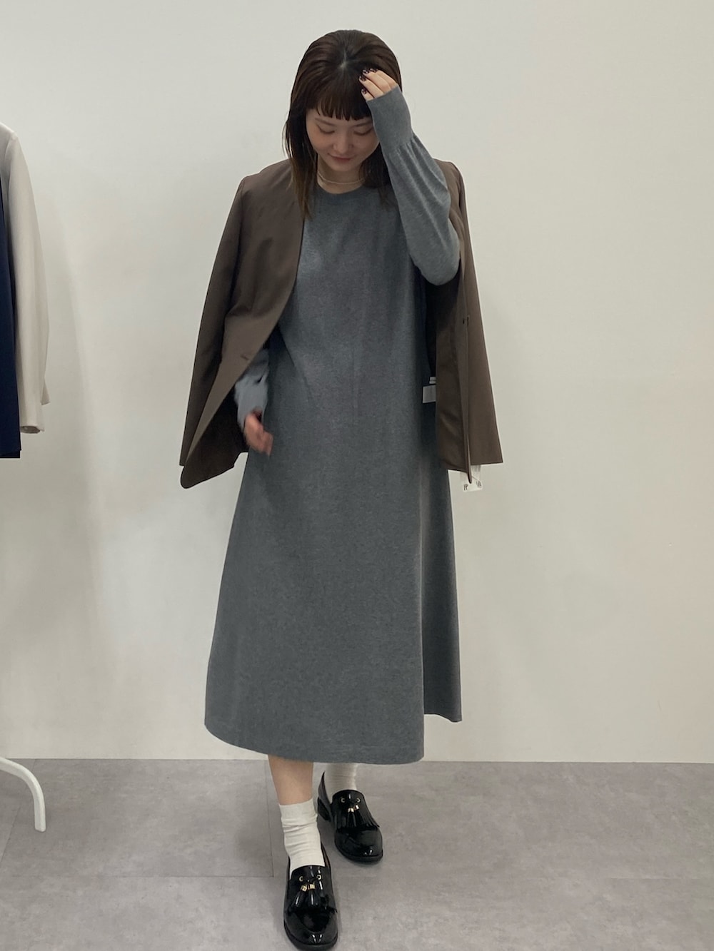 グレー系のワンピース、グレー系のワンピース、ブラウン系のジャケット/アウターを着用したレディースの秋コーディネートの2枚目の写真