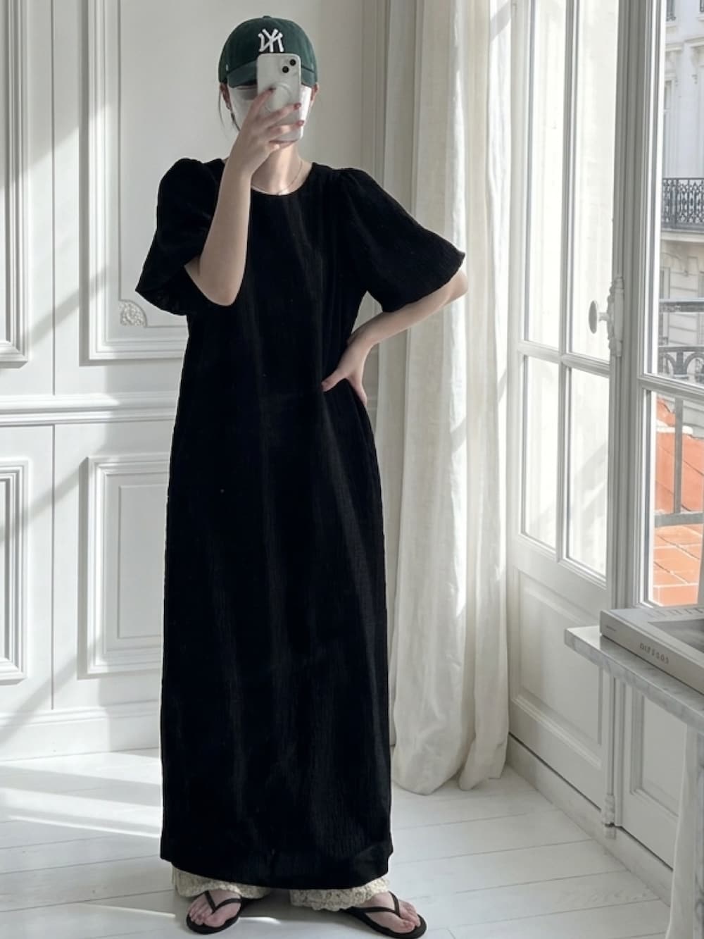 ブラック系のワンピース、ホワイト系のパンツを着用したレディースの春コーディネートの2枚目の写真