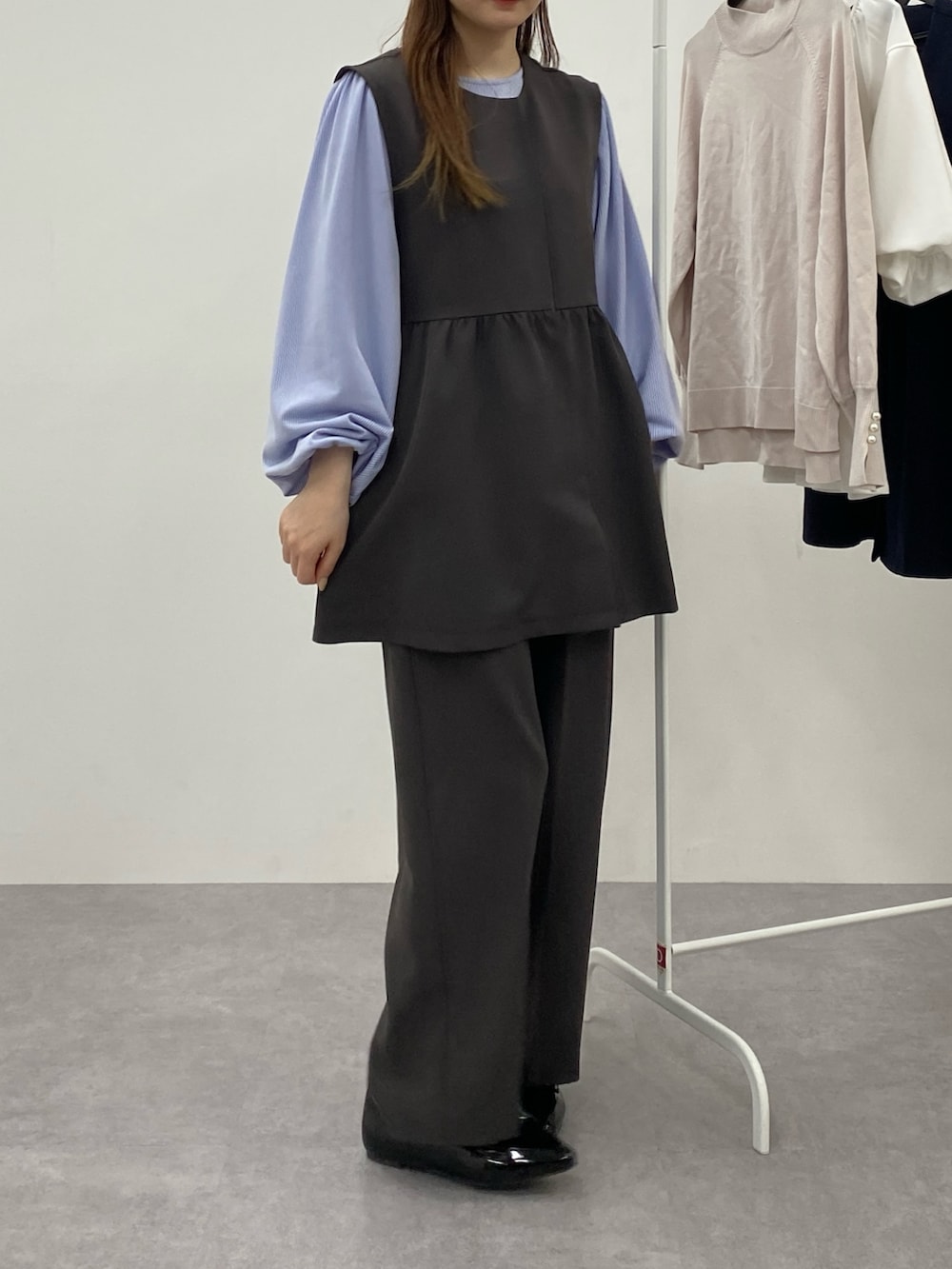 グレー系のベスト、グレー系のスラックス、ブルー系のTシャツ/カットソーを着用したレディースの秋コーディネートの2枚目の写真