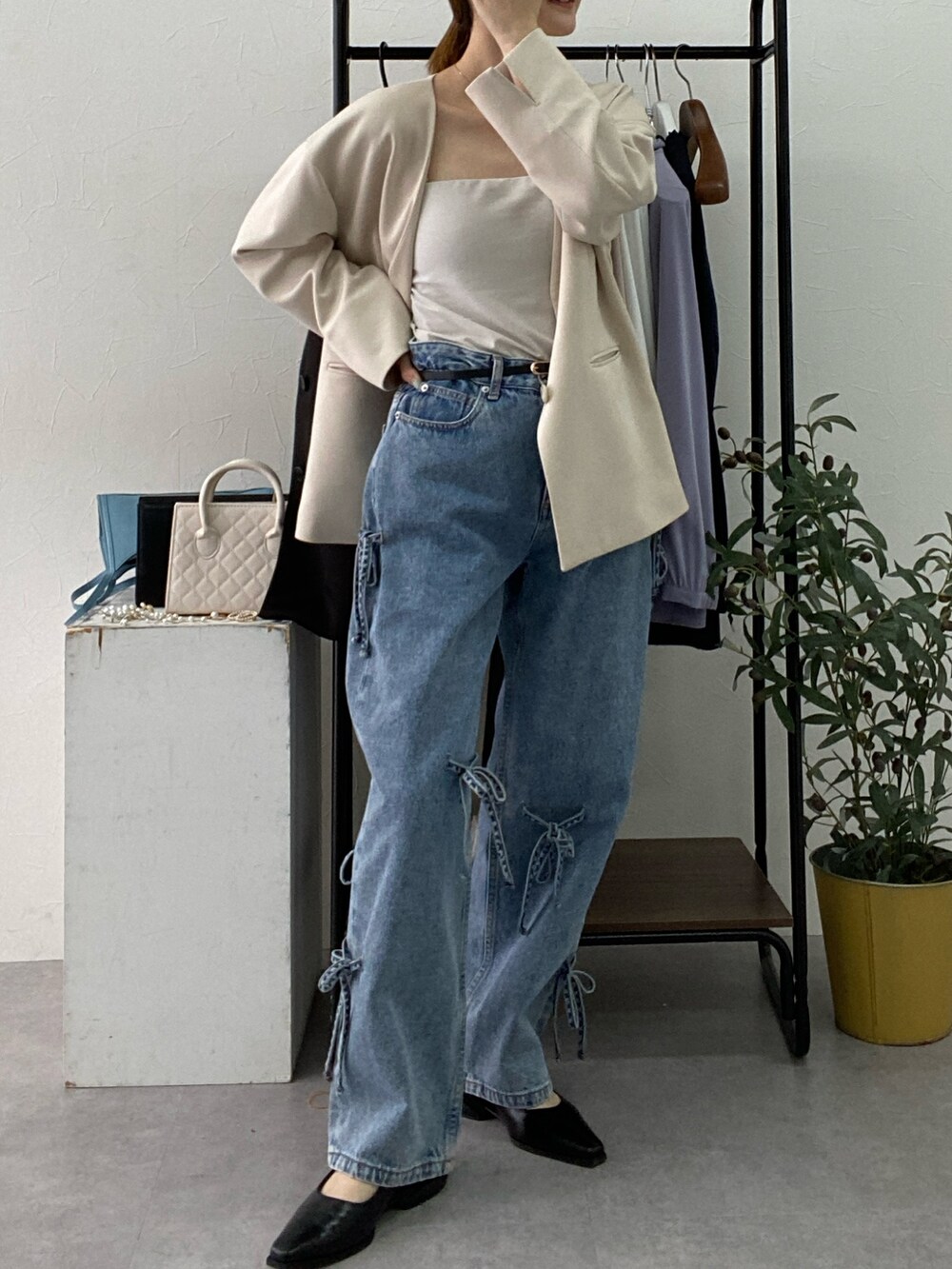 ベージュ系のフォーマルスーツ/小物、ホワイト系のタンクトップ、ブルー系のデニムパンツを着用したレディースの冬コーディネートの2枚目の写真