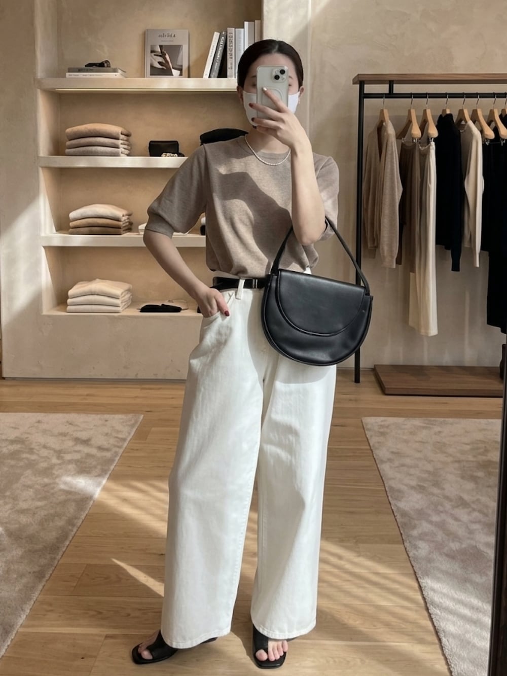 グレー系のニット/セーター、ホワイト系のデニムパンツ、ホワイト系のデニムパンツを着用したレディースの春コーディネートの2枚目の写真