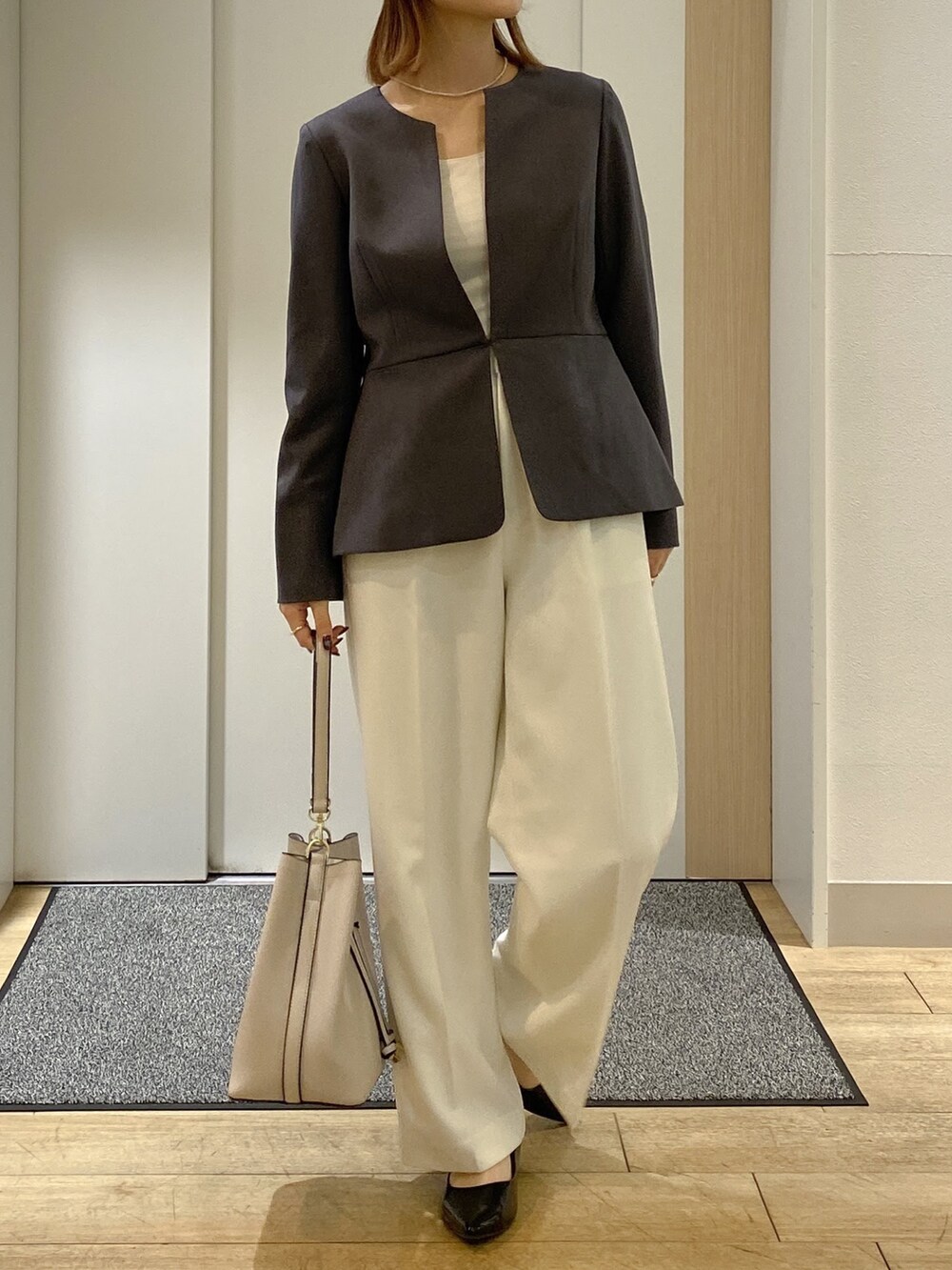 グレー系のスーツセットを着用したレディースの秋コーディネートの2枚目の写真