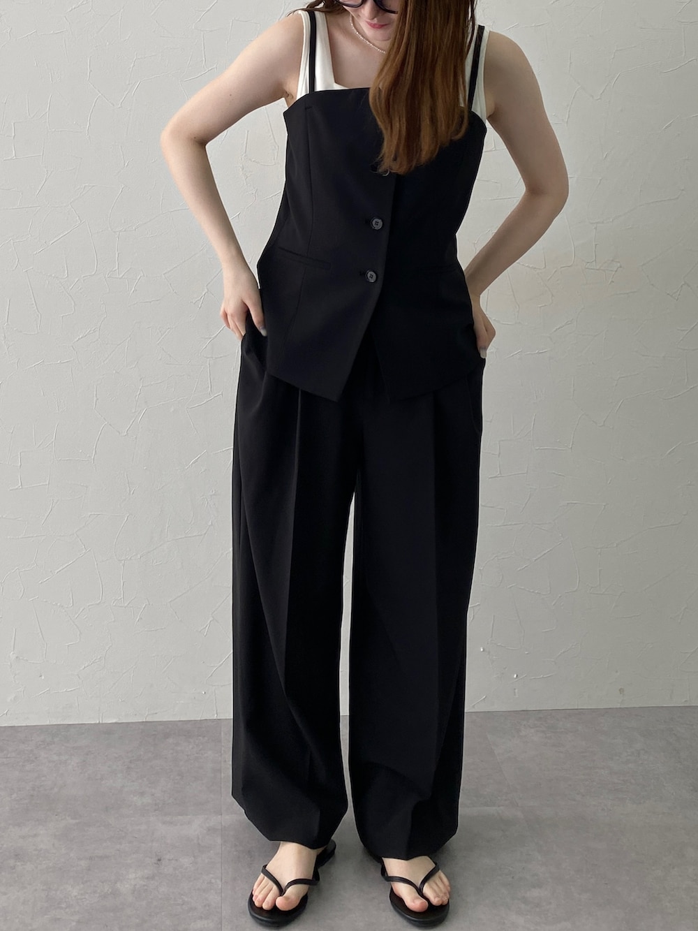 ホワイト系のタンクトップ、ブラック系のフォーマルスーツ/小物、ブラック系のスーツセットを着用したレディースの夏コーディネートの2枚目の写真