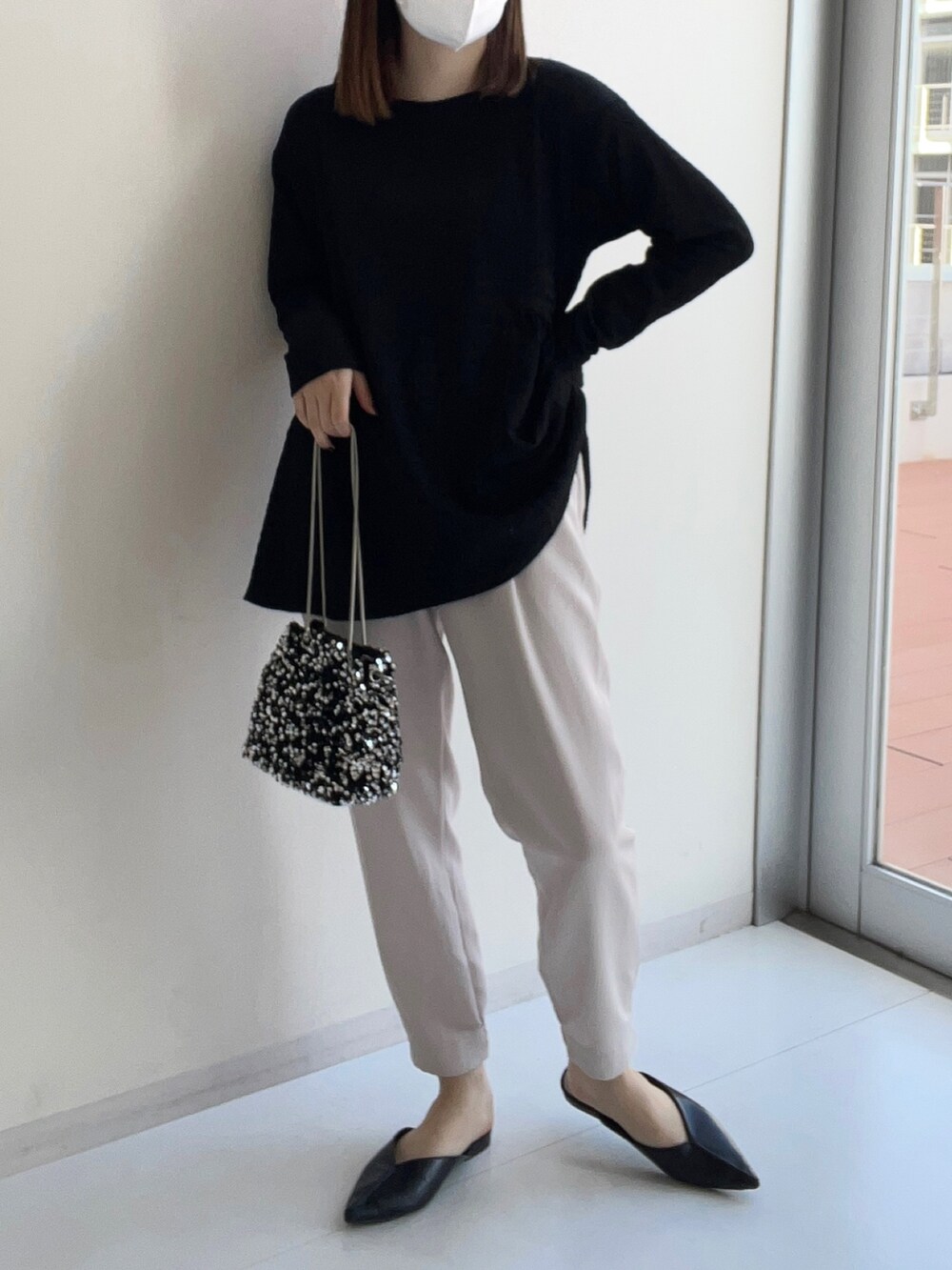 ブラック系のニット/セーター、ベージュ系のその他パンツを着用したレディースの冬コーディネートの2枚目の写真