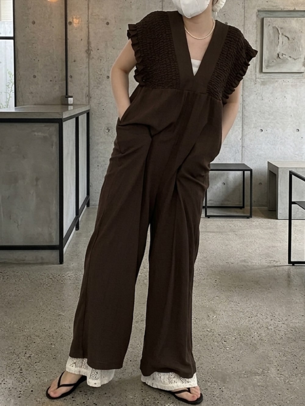 ブラウン系のオールインワン・サロペット、ホワイト系のパンツ、ブラック系のその他パンツを着用したレディースの春コーディネートの2枚目の写真