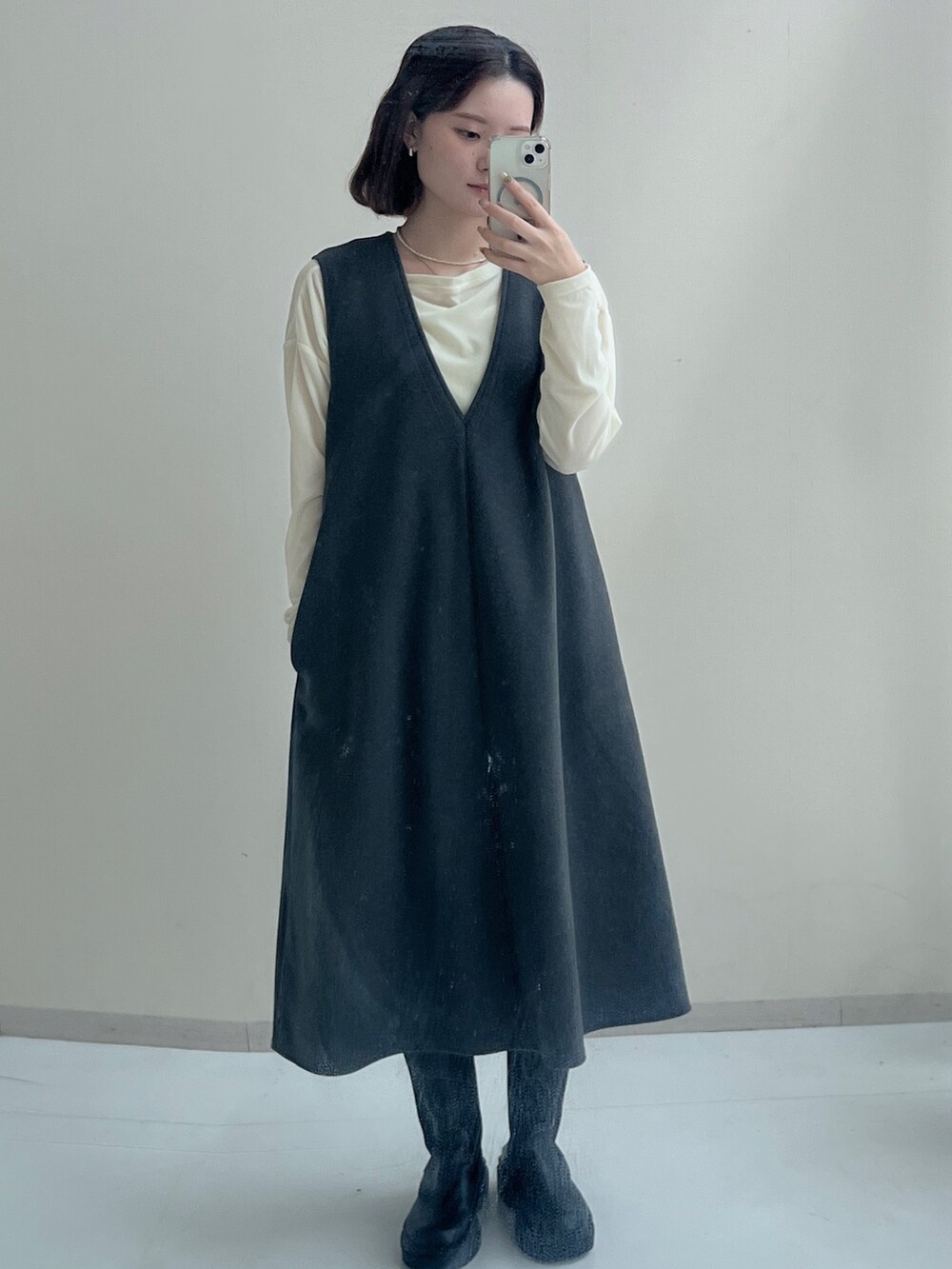 ベージュ系のTシャツ/カットソー、ホワイト系のTシャツ/カットソー、グレー系のジャンパースカートを着用したレディースの秋コーディネートの2枚目の写真