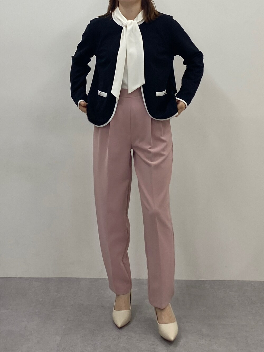 ホワイト系のシャツ/ブラウス、ブラック系のノーカラージャケット、ピンク系のスラックスを着用したレディースの冬コーディネートの2枚目の写真