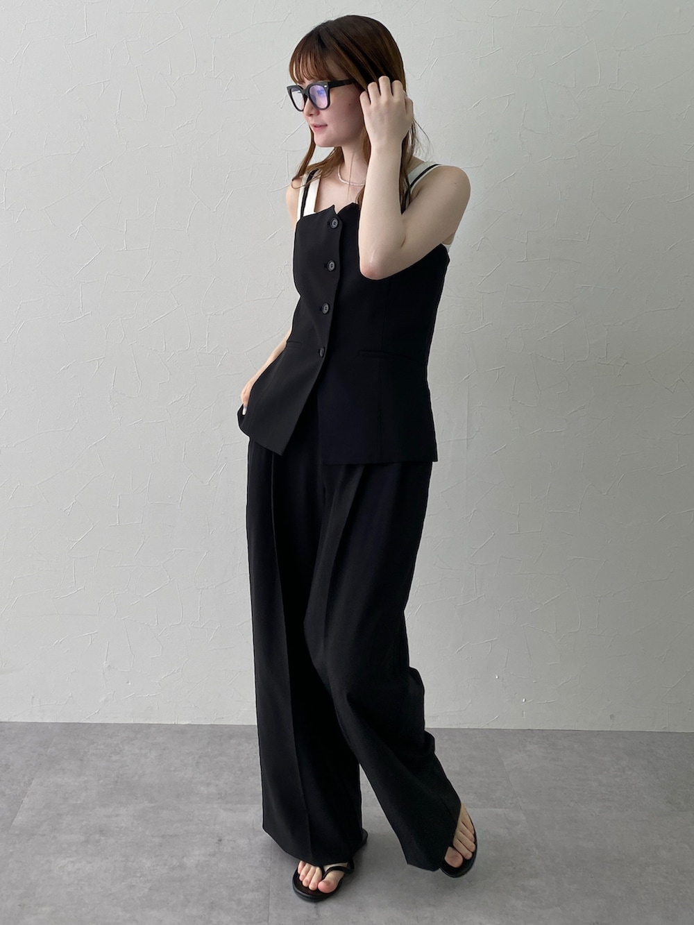 ホワイト系のタンクトップ、ブラック系のフォーマルスーツ/小物、ブラック系のスーツセットを着用したレディースの夏コーディネートの3枚目の写真