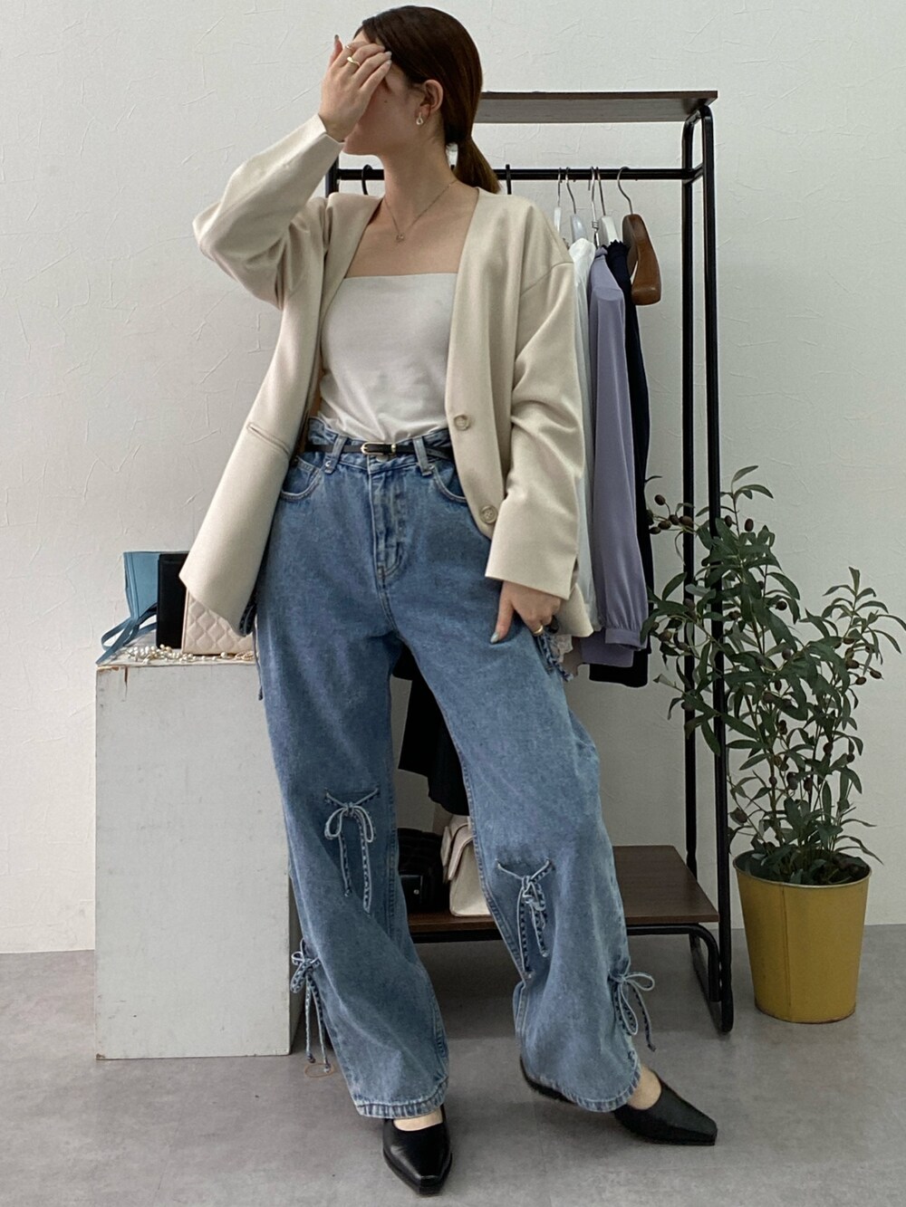 ベージュ系のフォーマルスーツ/小物、ホワイト系のタンクトップ、ブルー系のデニムパンツを着用したレディースの冬コーディネートの3枚目の写真