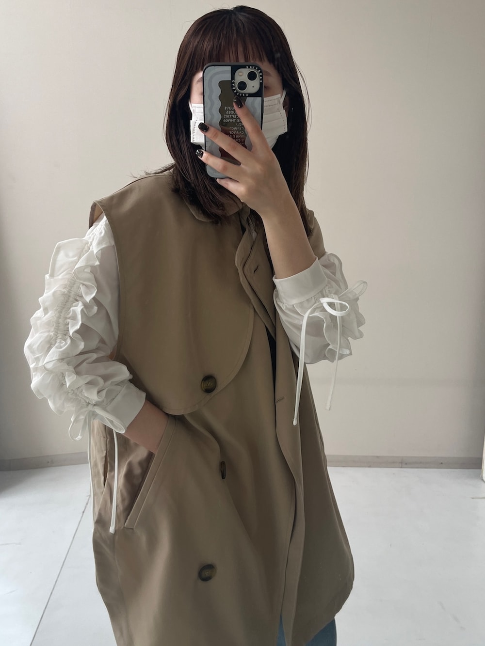 ホワイト系のTシャツ/カットソー、ブルー系のパンツ、ベージュ系のベストを着用したレディースの秋コーディネートの2枚目の写真