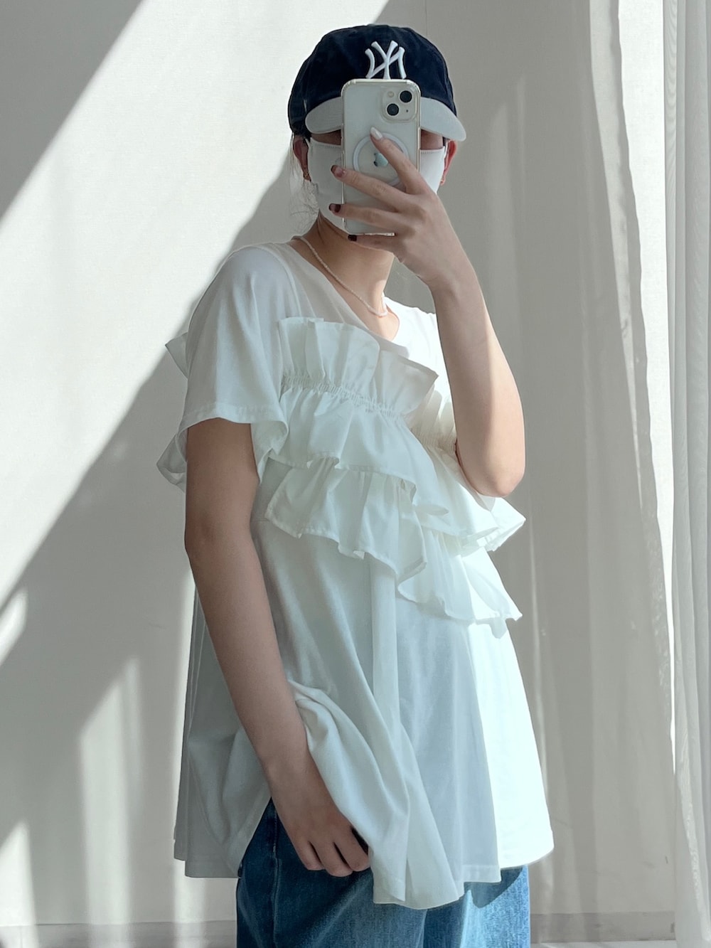 ブルー系のデニムパンツ、ホワイト系のTシャツ/カットソーを着用したレディースの春コーディネートの3枚目の写真