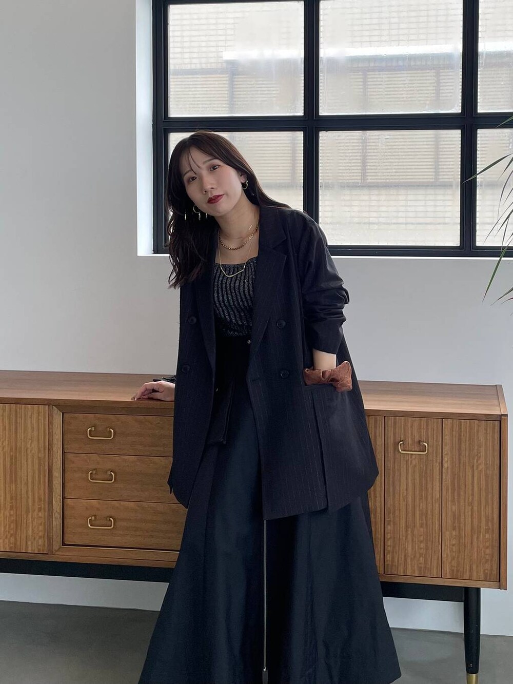 ブラック系のタンクトップ、ブラック系のショルダーバッグ、ブラック系のブーツを着用したレディースの夏コーディネートの4枚目の写真