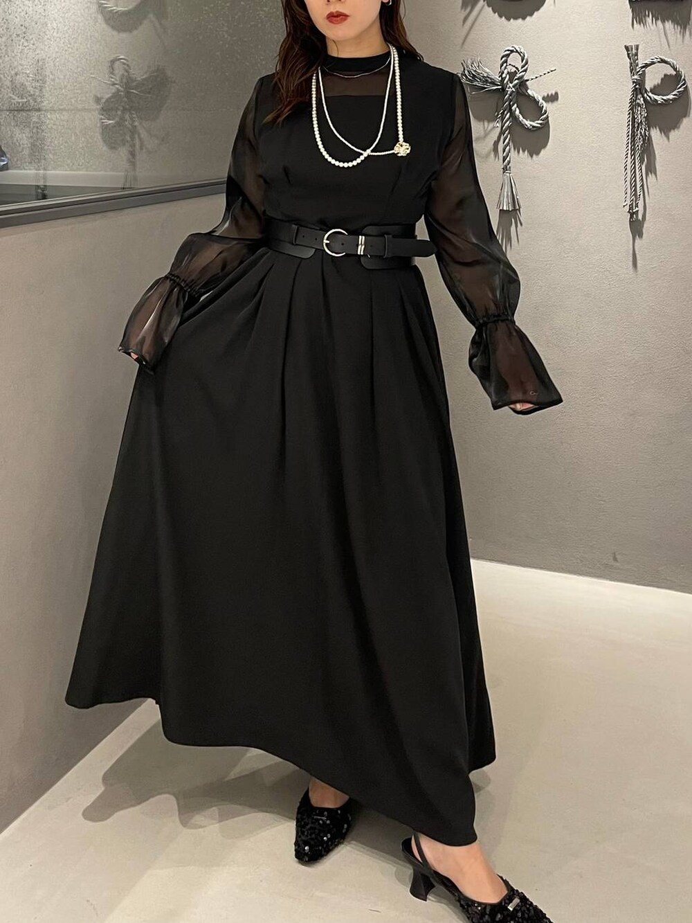 ブラック系のパンプス、ブラック系のベルト、ゴールド系のネックレスを着用したレディースの秋コーディネートの3枚目の写真