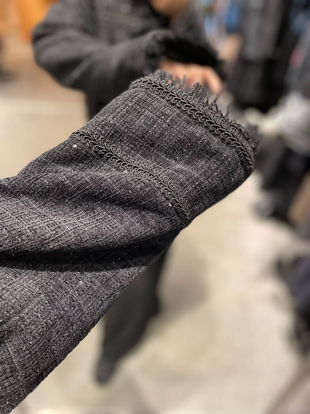 ブラック系のノーカラージャケット、ブラック系のスラックスを着用したレディースの秋コーディネートの4枚目の写真