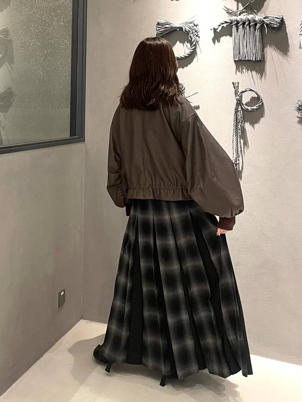 レッド系のニット/セーター、ブラック系のブーツ、ブラウン系のブルゾンを着用したレディースの秋コーディネートの3枚目の写真