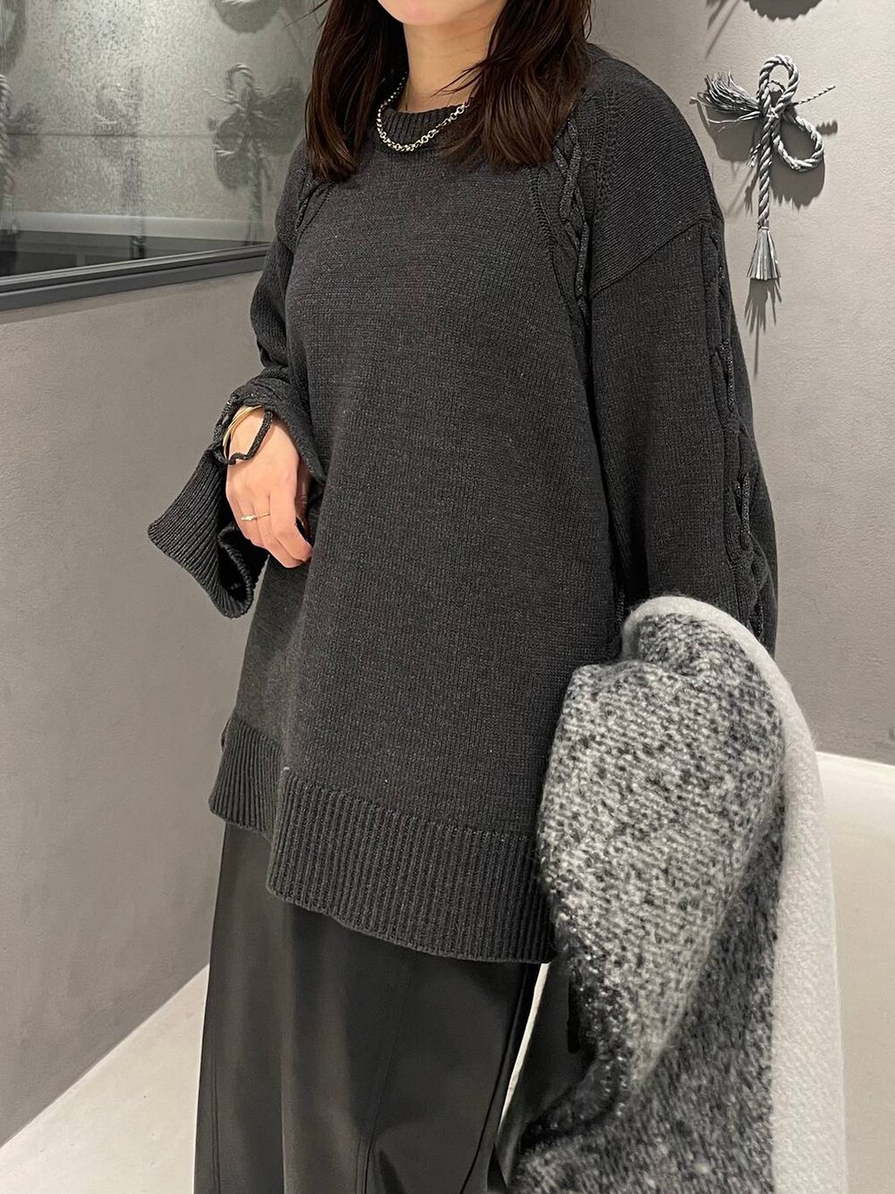 ブラック系のパンプス、グレー系のニット/セーター、ブラック系のスカートを着用したレディースの秋コーディネートの5枚目の写真