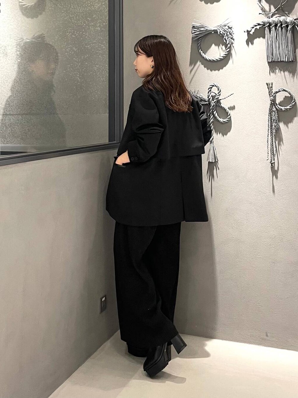 ホワイト系のタンクトップ、ブラック系のブーツ、ブラック系のその他パンツを着用したレディースの秋コーディネートの2枚目の写真