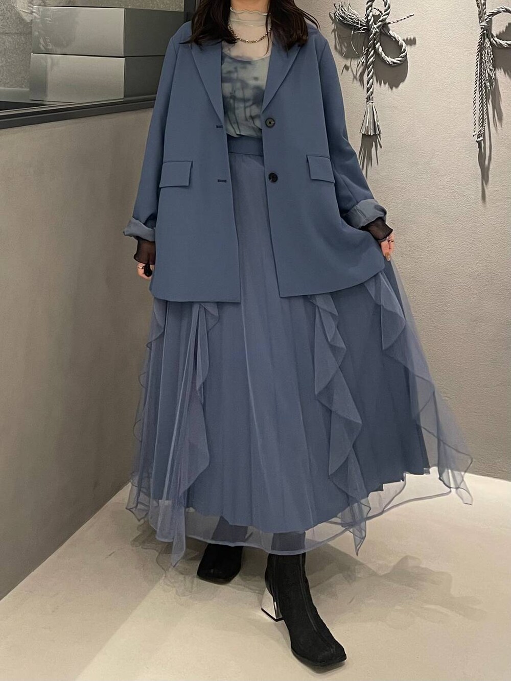 ブラック系のブーツ、グリーン系のTシャツ/カットソー、ブルー系のテーラードジャケットを着用したレディースの冬コーディネートの4枚目の写真