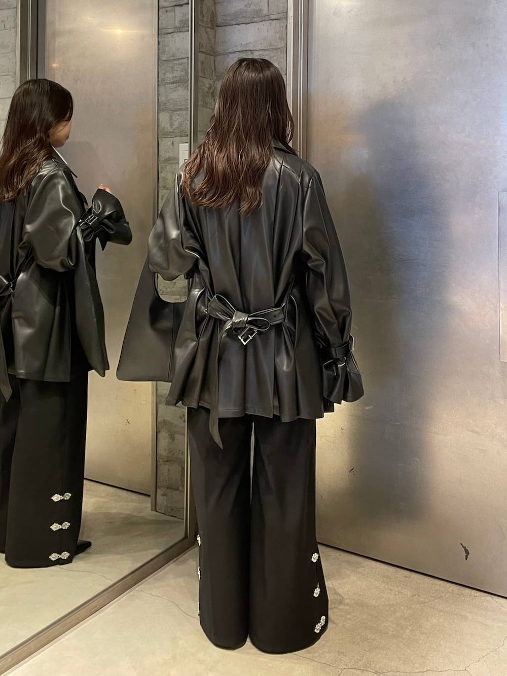 ブラック系のトートバッグ、ブラック系のパンプス、ブラック系のトレンチコートを着用したレディースの冬コーディネートの4枚目の写真