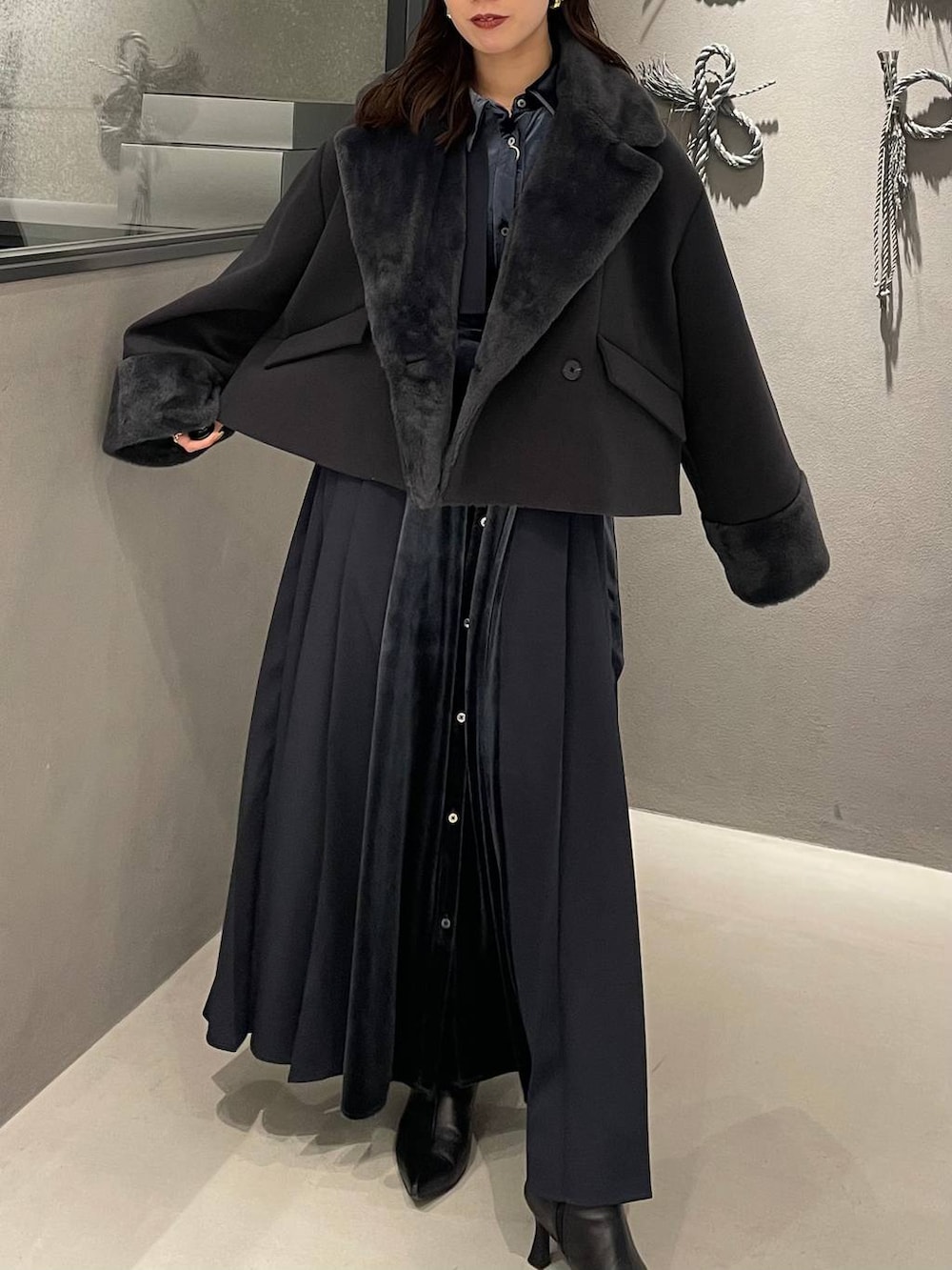 ブルー系のワンピース、ブラック系のブーツ、グレー系のその他アウターを着用したレディースの冬コーディネートの5枚目の写真