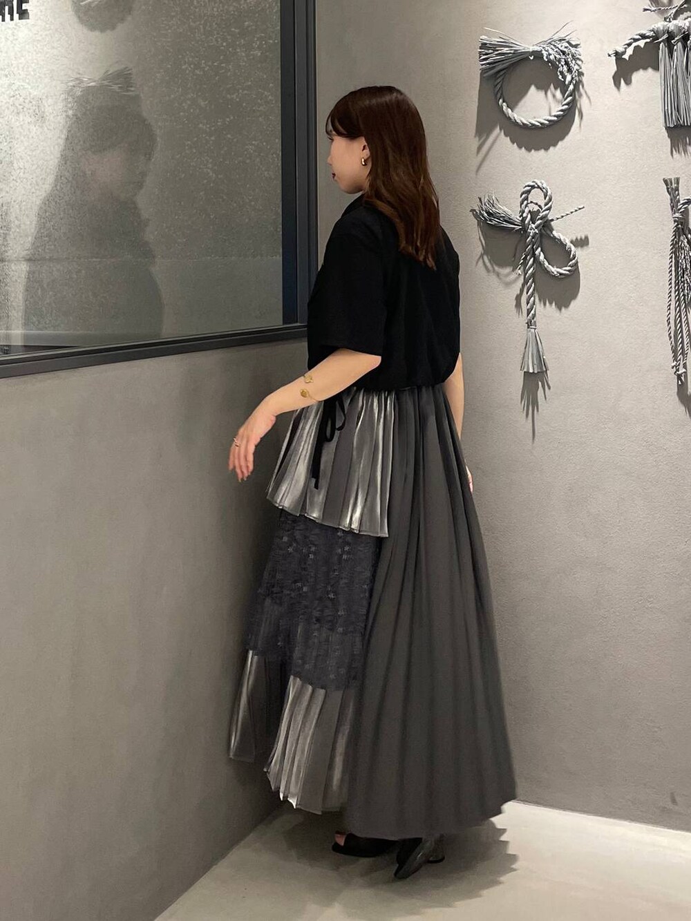 ブラック系のサンダル、グレー系のスカート、ブラック系のシャツ/ブラウスを着用したレディースの夏コーディネートの2枚目の写真