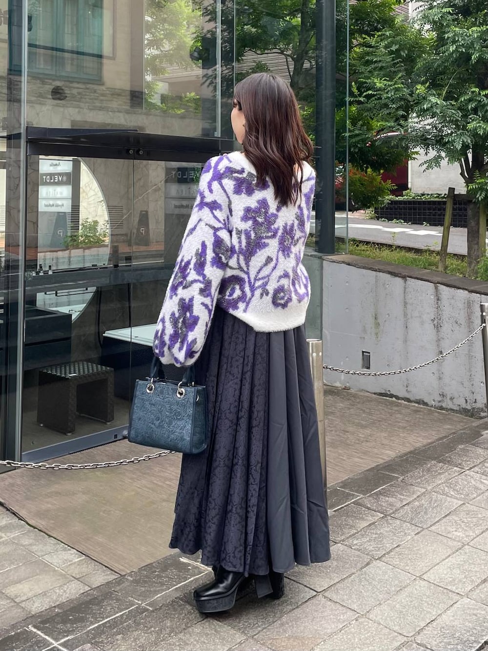 グレー系のショルダーバッグ、ホワイト系のカーディガン/ボレロ、ブラック系のブーツを着用したレディースの秋コーディネートの3枚目の写真