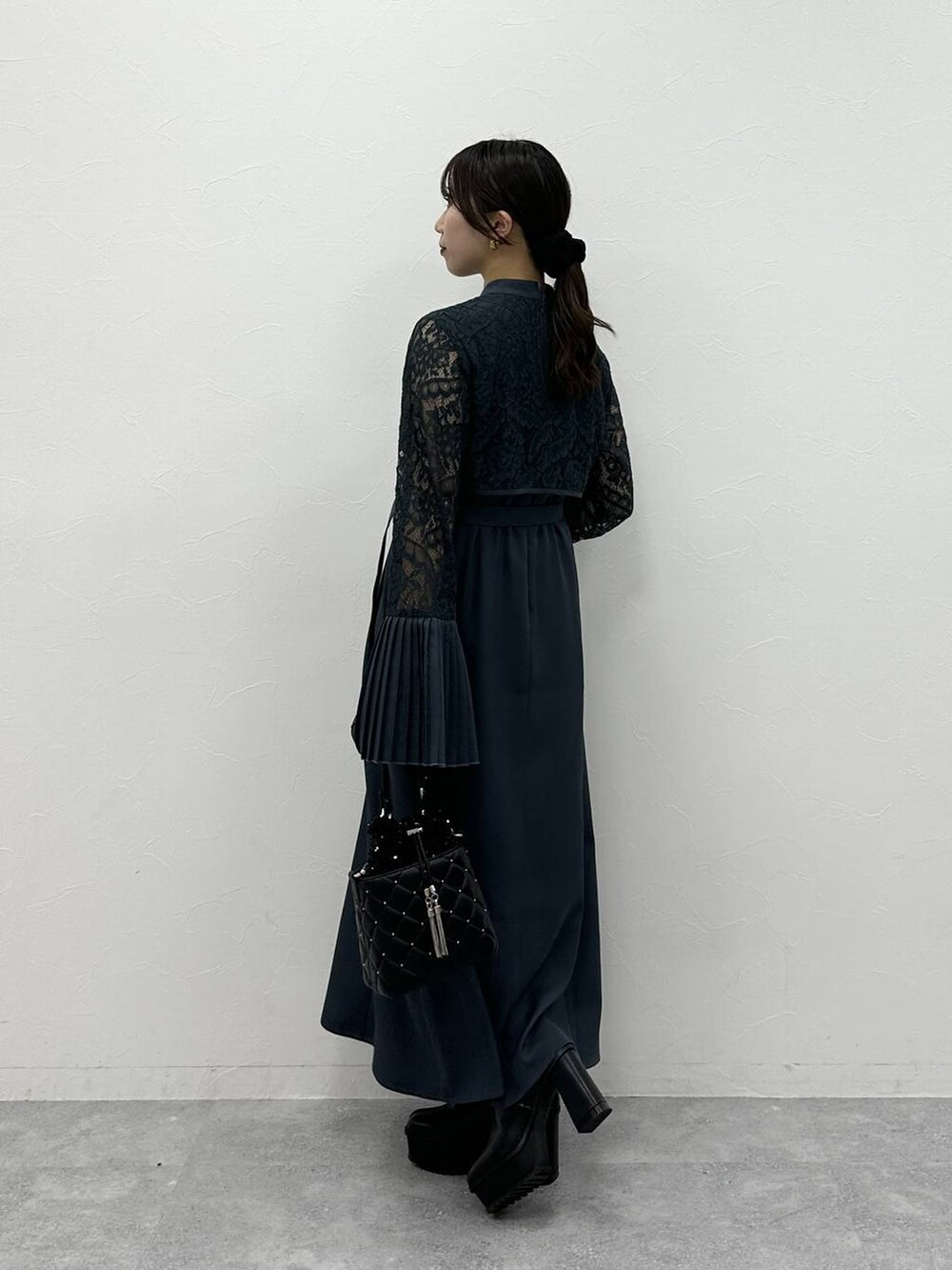 ブラック系のブーツ、ブラック系のショルダーバッグ、ブルー系のドレスを着用したレディースの夏コーディネートの3枚目の写真