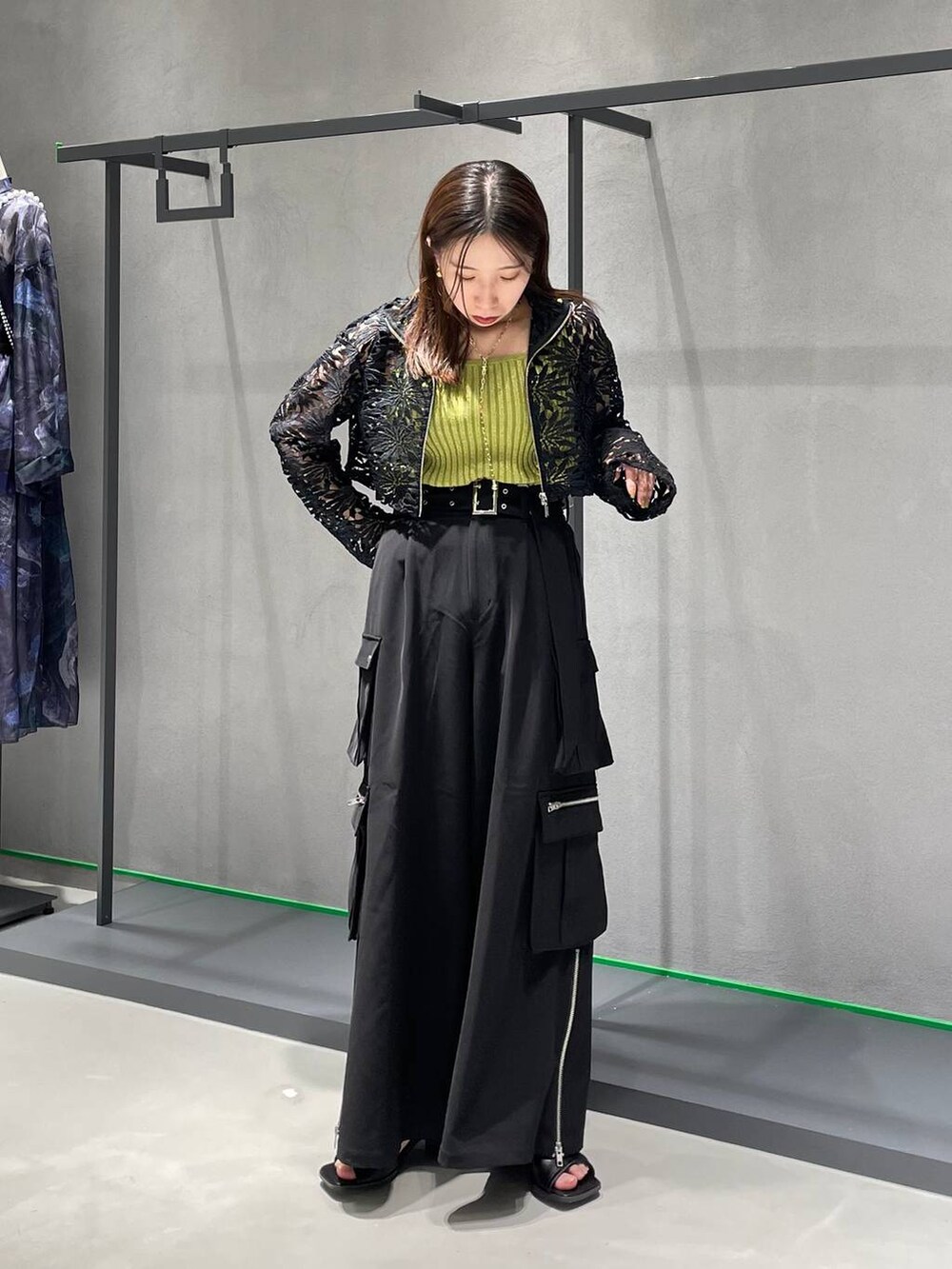 ブラック系のカーゴパンツ、ブラック系のサンダル、イエロー系のタンクトップを着用したレディースの春コーディネートの4枚目の写真