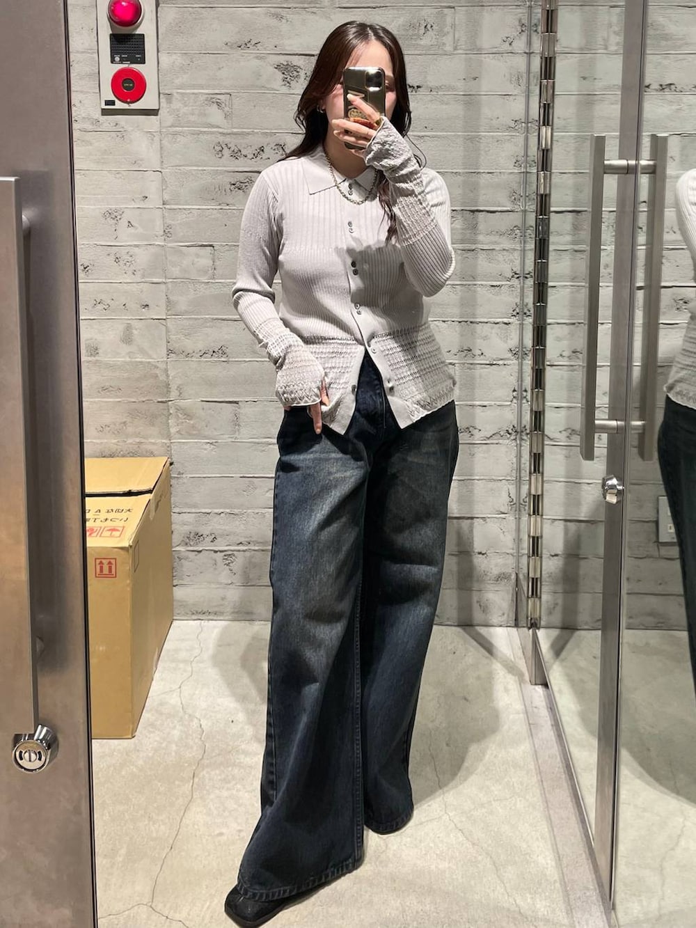 ブルー系のデニムパンツ、ブラック系のブーツ、グレー系のカーディガン/ボレロを着用したレディースの冬コーディネートの2枚目の写真