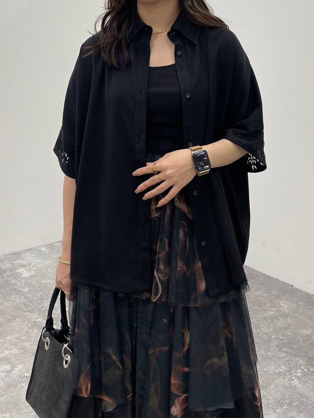 ブラック系のサンダル、ブラック系のショルダーバッグ、オレンジ系のスカートを着用したレディースの夏コーディネートの4枚目の写真