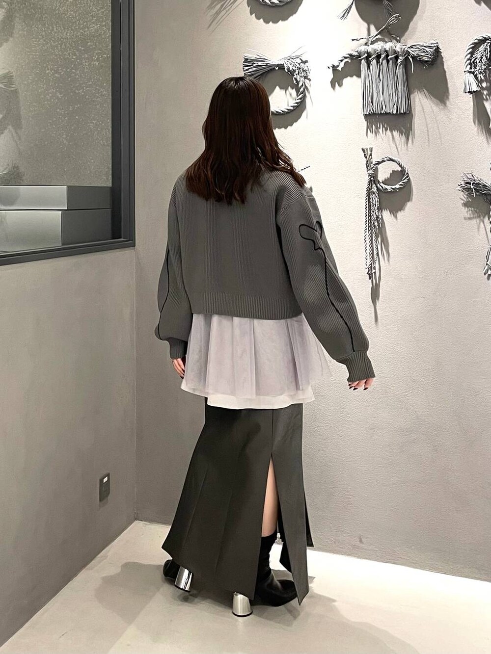 ブラック系のブーツ、グレー系のシャツ/ブラウス、グレー系のニット/セーターを着用したレディースの冬コーディネートの3枚目の写真