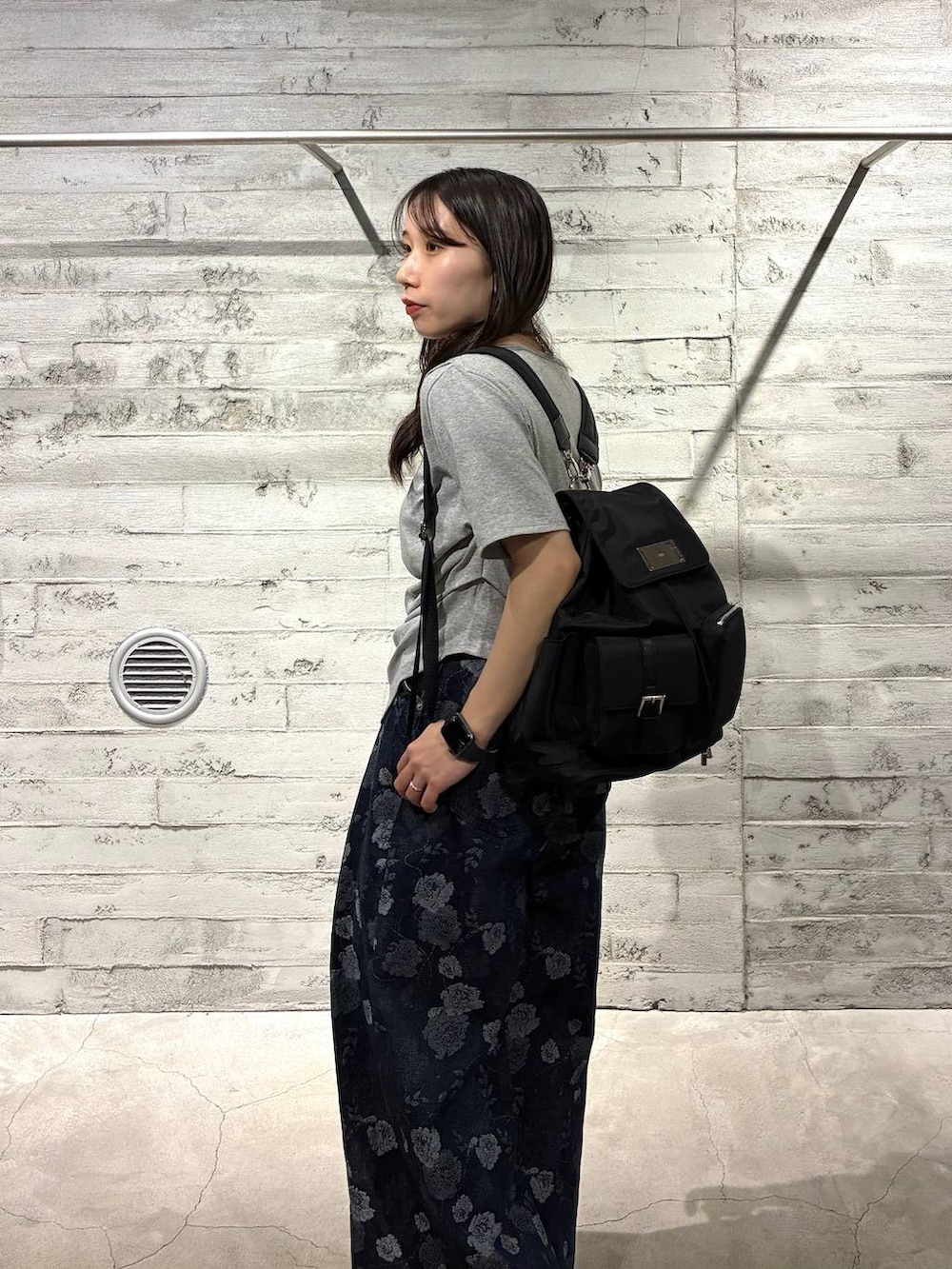 ブラック系のバックパック/リュック、ブルー系のデニムパンツ、ブラック系のサンダルを着用したレディースの春コーディネートの6枚目の写真