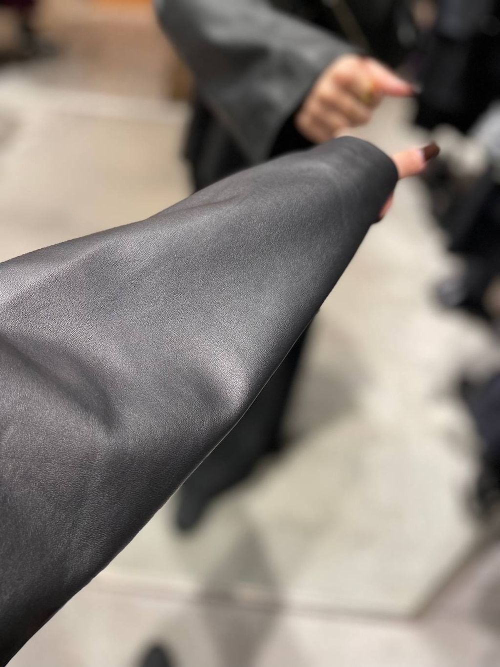 ブラック系のライダースジャケット、ブラック系のスラックスを着用したレディースの秋コーディネートの4枚目の写真