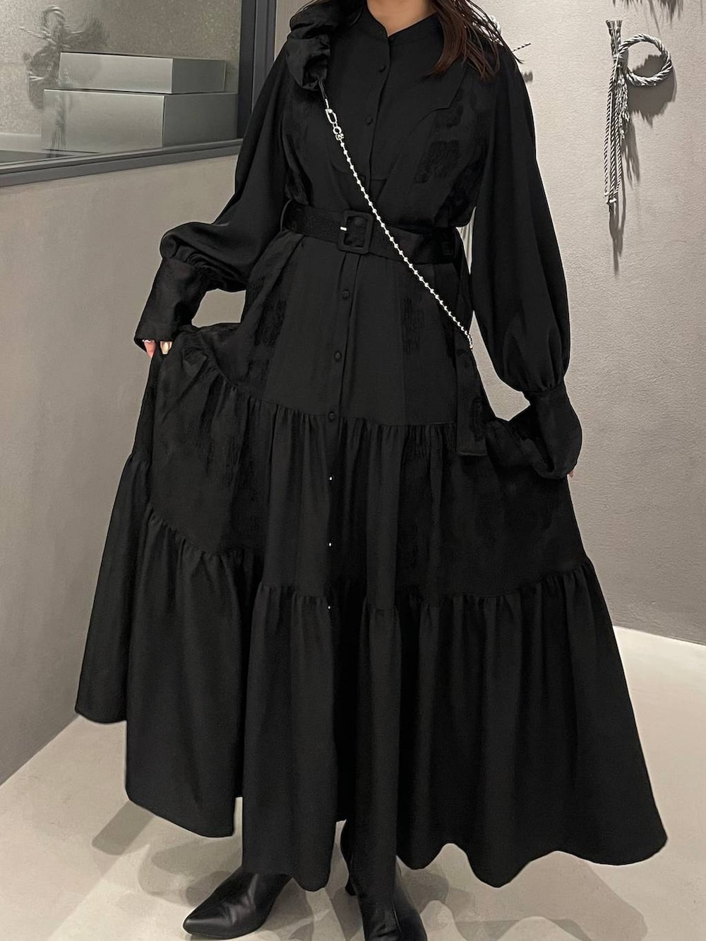 ブラック系のブーツ、ブラック系のワンピース、ブラック系のスマホグッズを着用したレディースの冬コーディネートの4枚目の写真