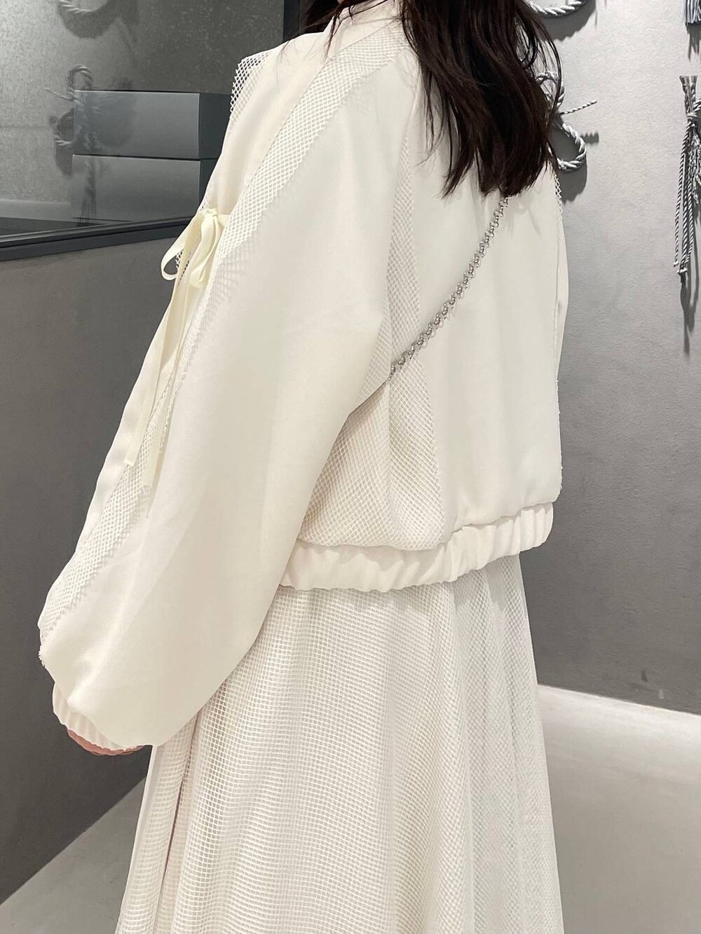 ブラック系のブーツ、ホワイト系のスカート、ホワイト系のブルゾンを着用したレディースの冬コーディネートの6枚目の写真