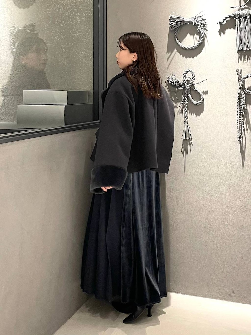 ブルー系のワンピース、ブラック系のブーツ、グレー系のその他アウターを着用したレディースの冬コーディネートの3枚目の写真