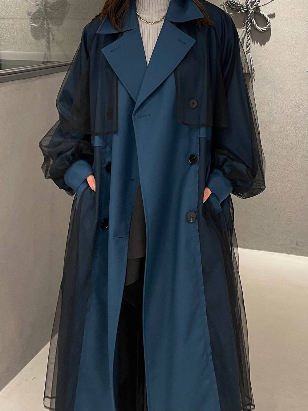 ブラック系のスカート、ブラック系のパンプス、ブルー系のトレンチコートを着用したレディースの秋コーディネートの4枚目の写真