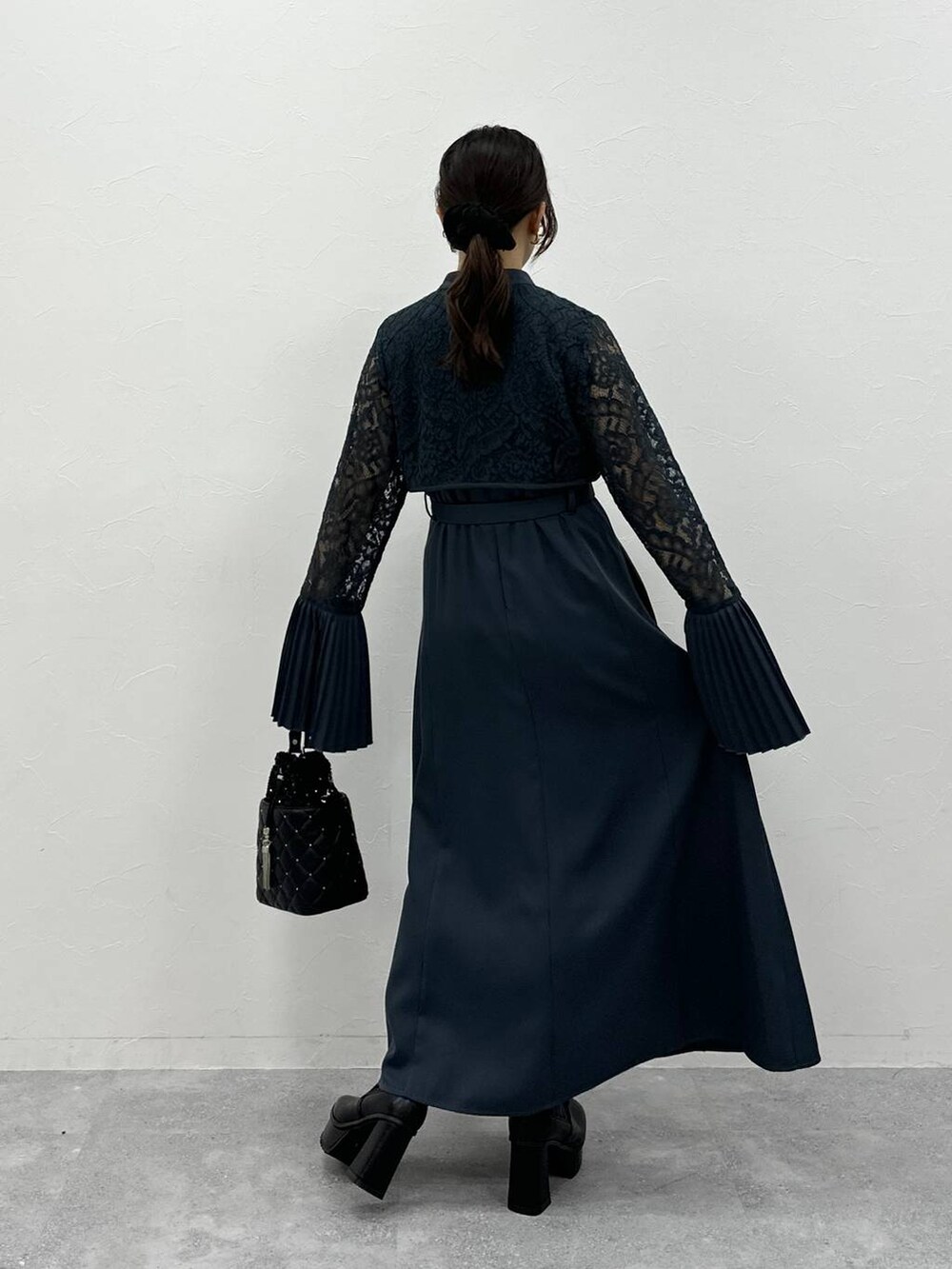 ブラック系のブーツ、ブラック系のショルダーバッグ、ブルー系のドレスを着用したレディースの夏コーディネートの4枚目の写真