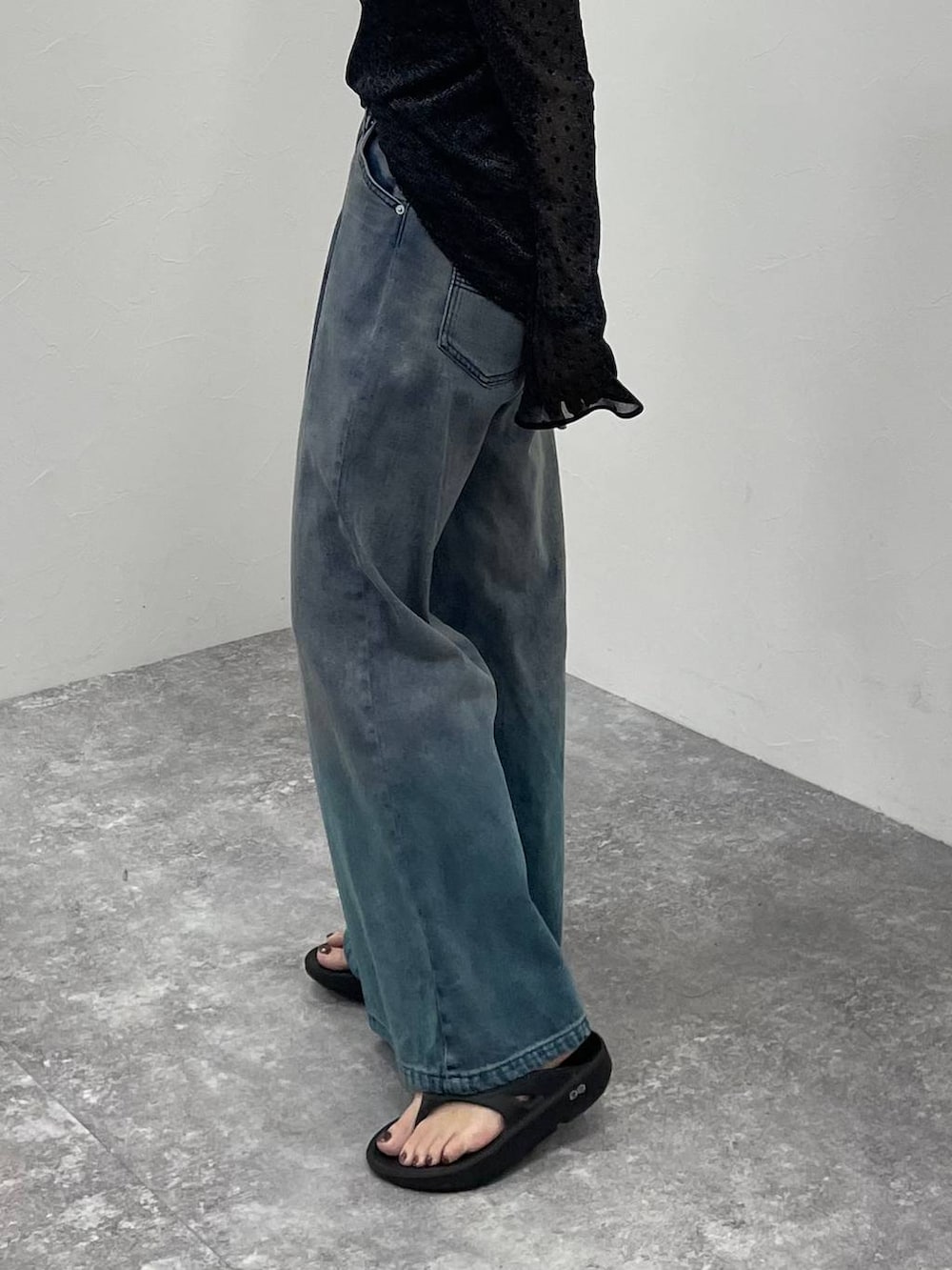 ブラック系のキャミソール、ブルー系のデニムパンツ、ブラック系のサンダルを着用したレディースの夏コーディネートの7枚目の写真