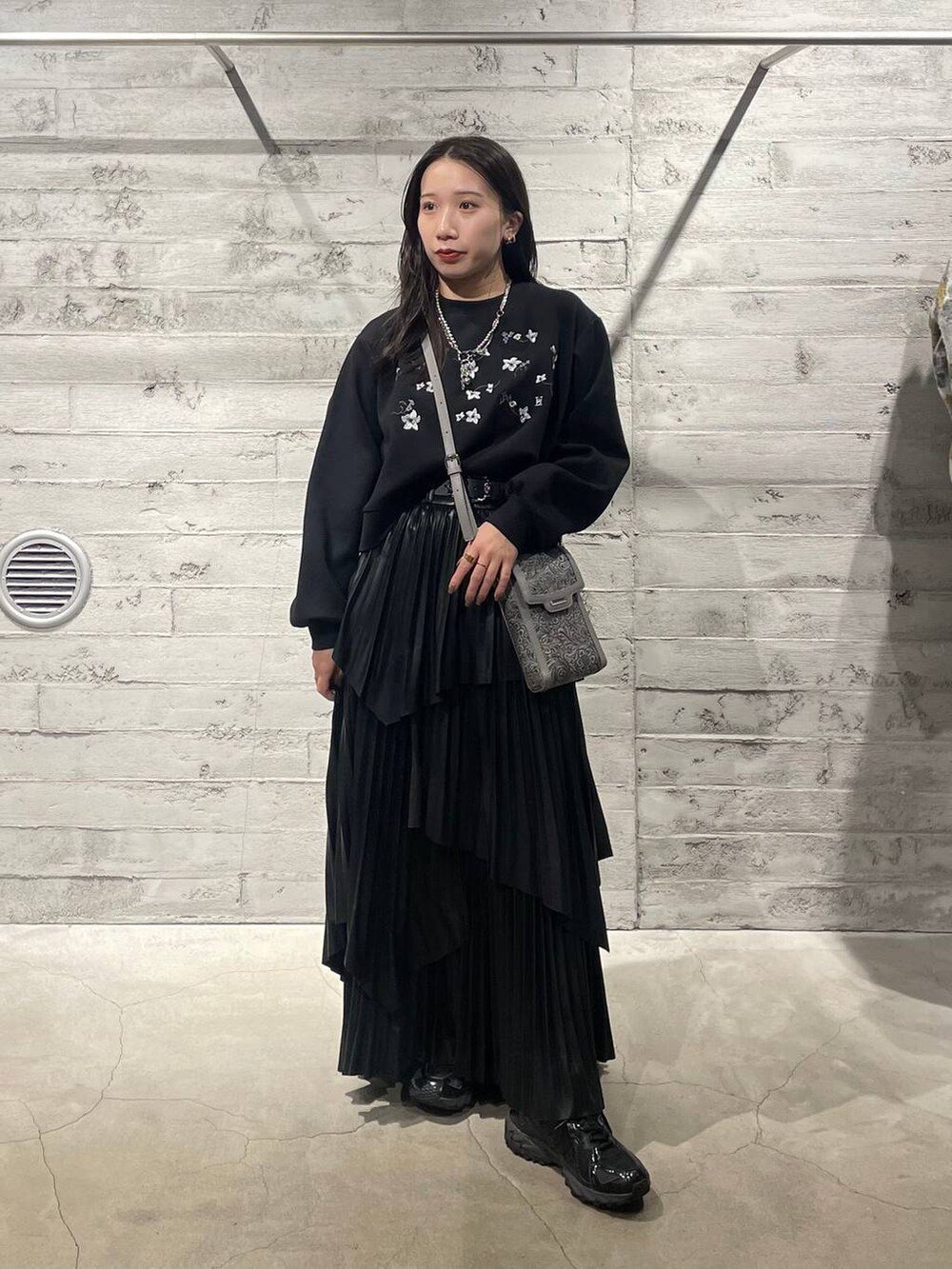 ブラック系のスウェット、グレー系のショルダーバッグ、ブラック系のスカートを着用したレディースの冬コーディネートの7枚目の写真