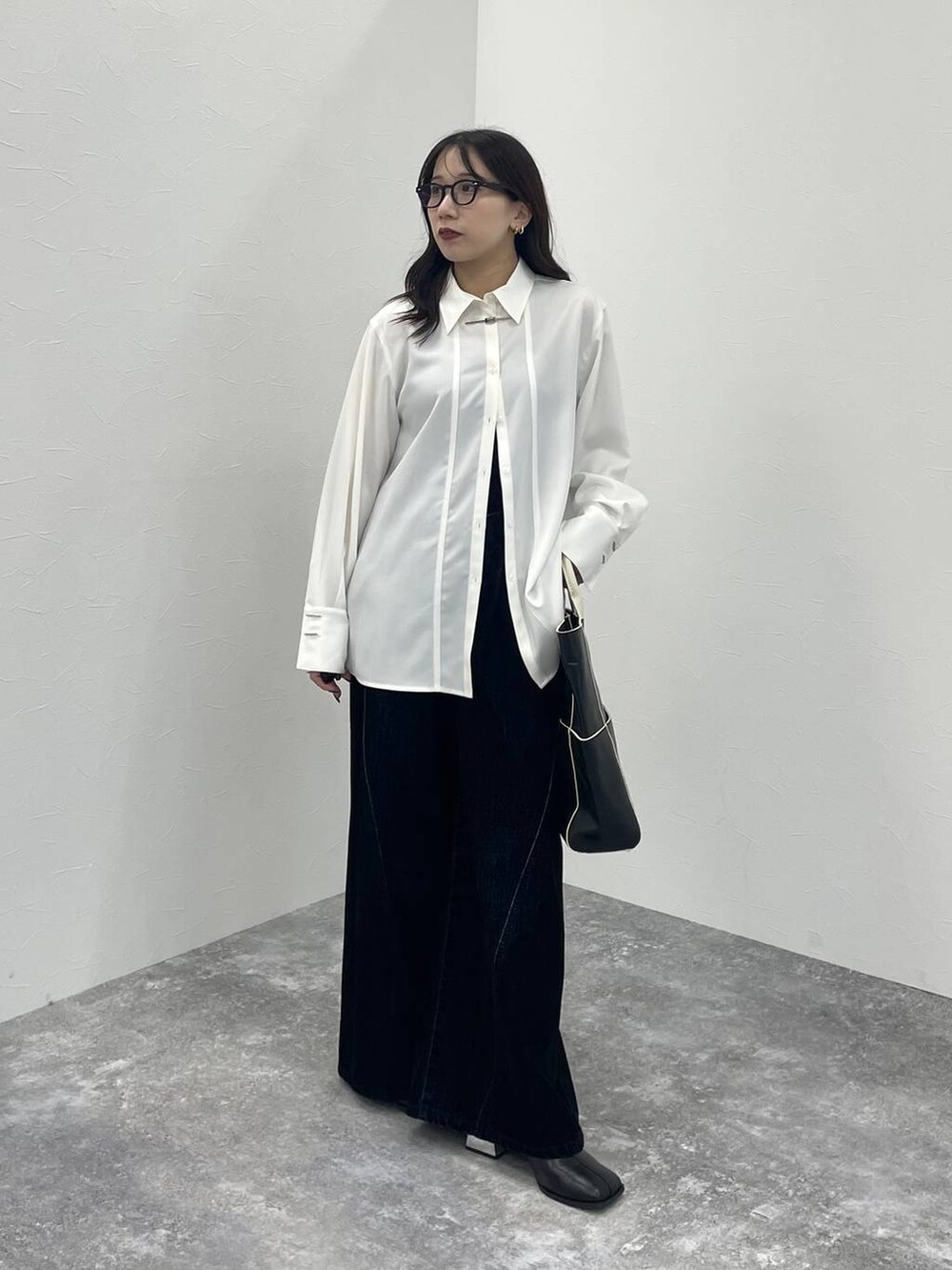 ブラック系のブーツ、ブラック系のショルダーバッグ、ホワイト系のシャツ/ブラウスを着用したレディースの秋コーディネートの2枚目の写真