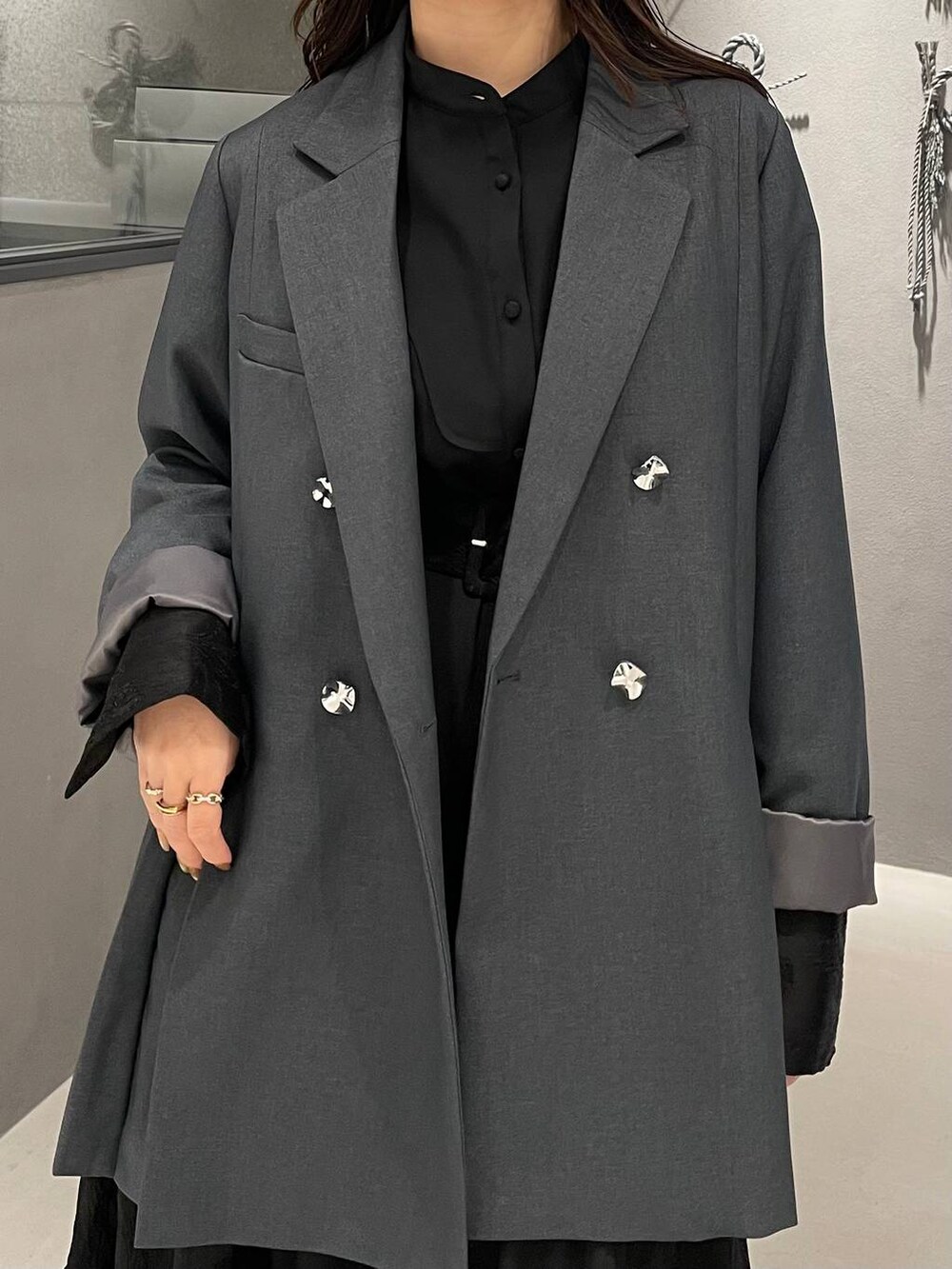 ブラック系のブーツ、グレー系のテーラードジャケット、ブラック系のワンピースを着用したレディースの冬コーディネートの5枚目の写真