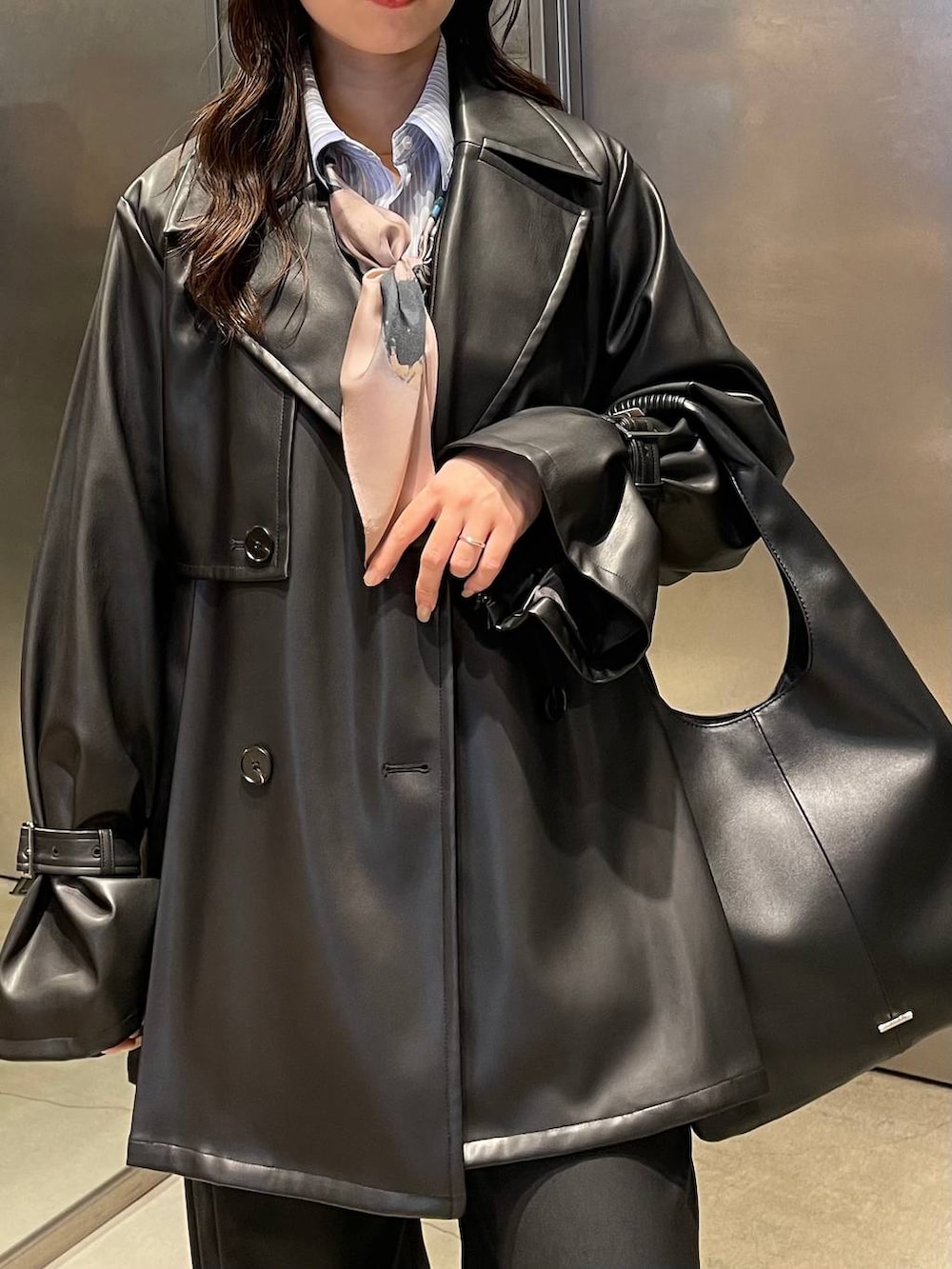 ブラック系のトートバッグ、ブラック系のパンプス、ブラック系のトレンチコートを着用したレディースの冬コーディネートの5枚目の写真