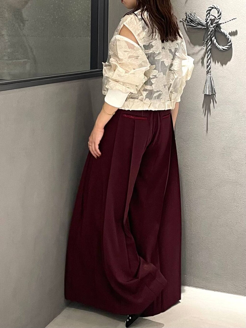 ブラック系のタンクトップ、ブラック系のパンプス、ホワイト系のブルゾンを着用したレディースの夏コーディネートの3枚目の写真