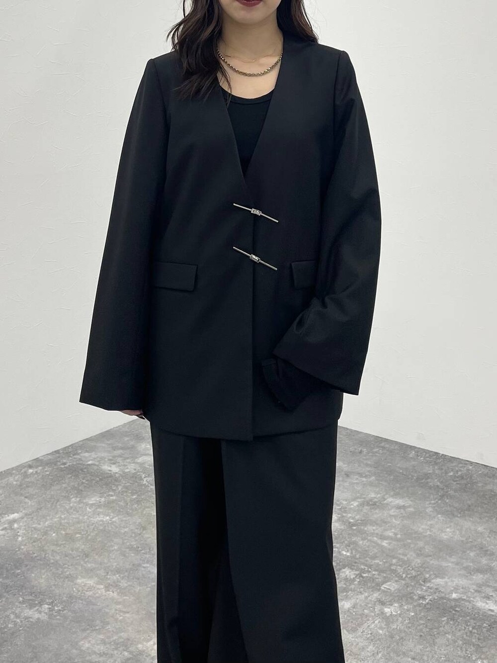 ブラック系のブーツ、ブラック系のノーカラージャケット、ブラック系のスラックスを着用したレディースの秋コーディネートの6枚目の写真