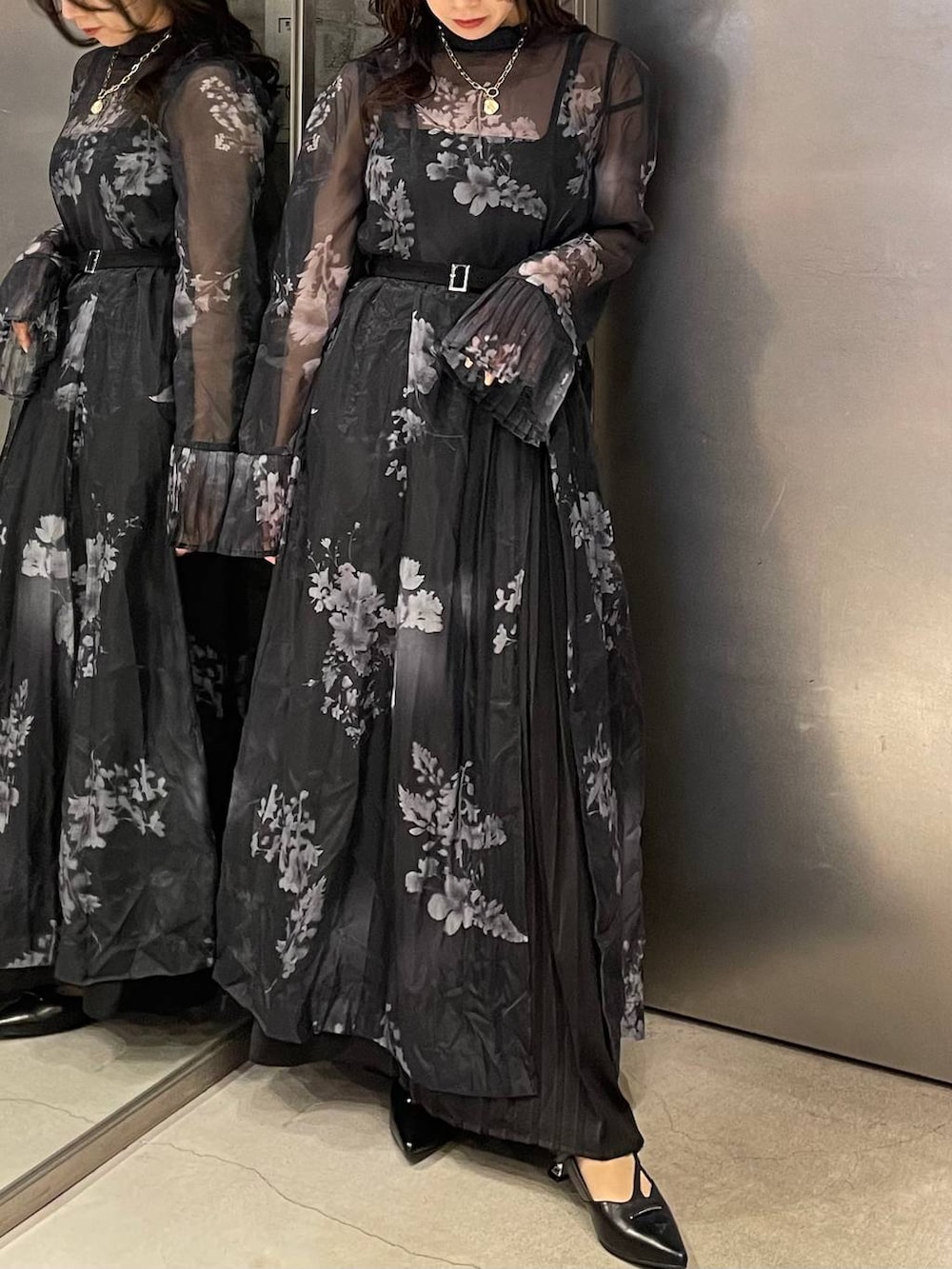 ブラック系のパンプス、ブラック系のワンピース、ゴールド系のネックレスを着用したレディースの冬コーディネートの7枚目の写真