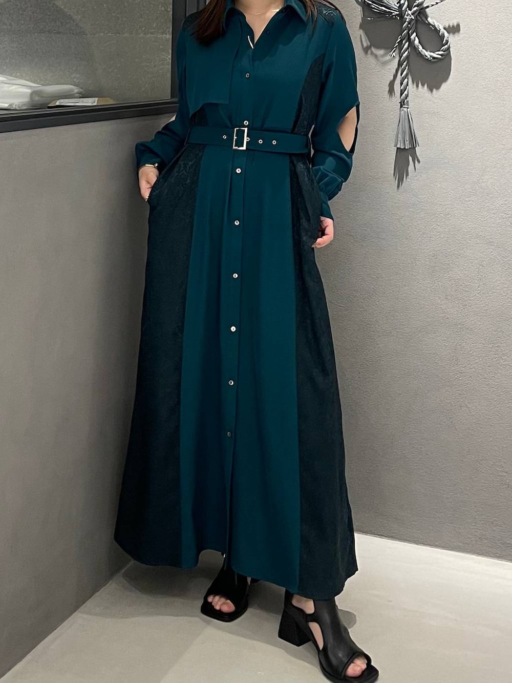 グリーン系のワンピース、ブラック系のサンダルを着用したレディースの春コーディネートの3枚目の写真