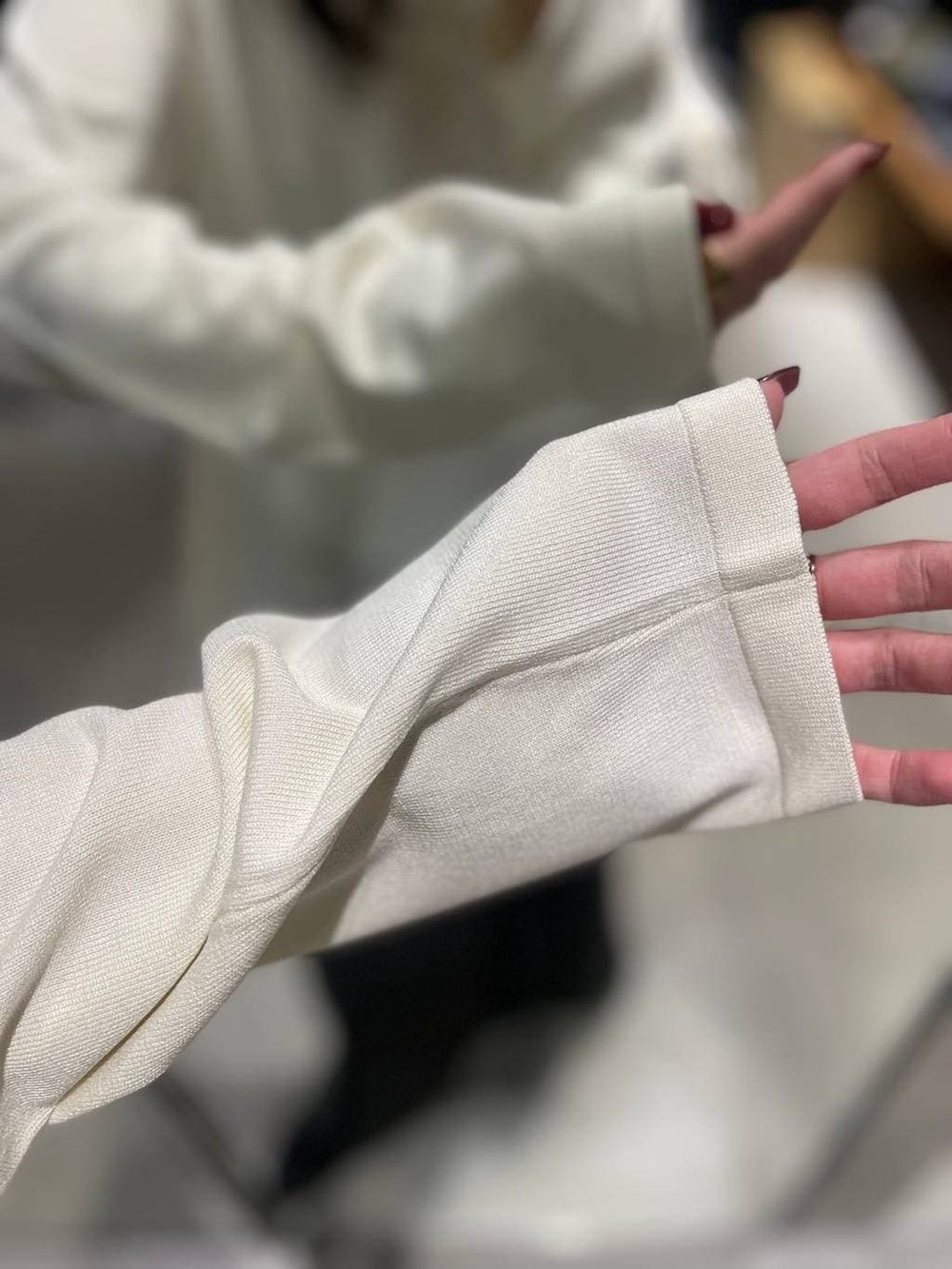 ホワイト系のニット/セーター、グレー系のスカートを着用したレディースの秋コーディネートの4枚目の写真